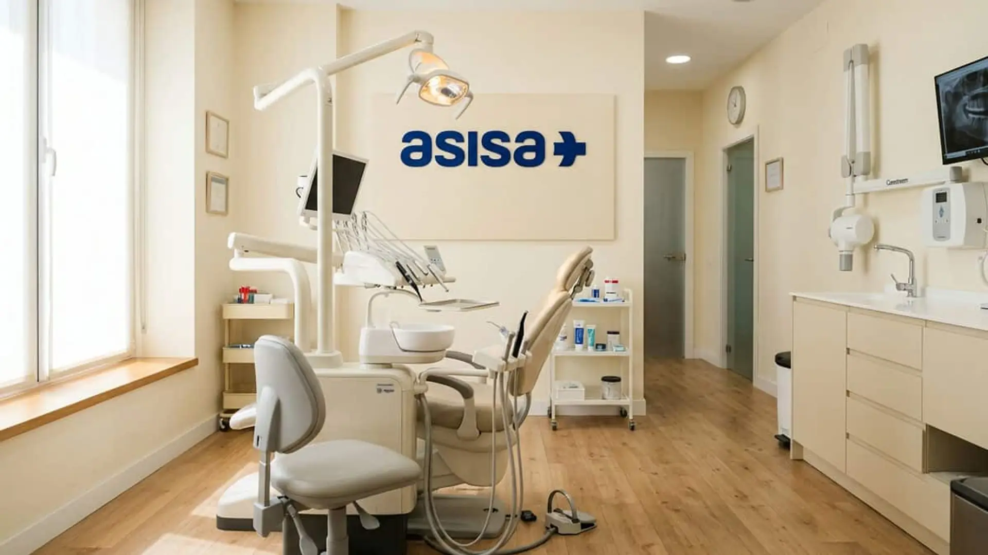 Interior de una clínica ASISA Dental con sillón odontológico, lámpara, instrumental dental y logotipo de ASISA en la pared.