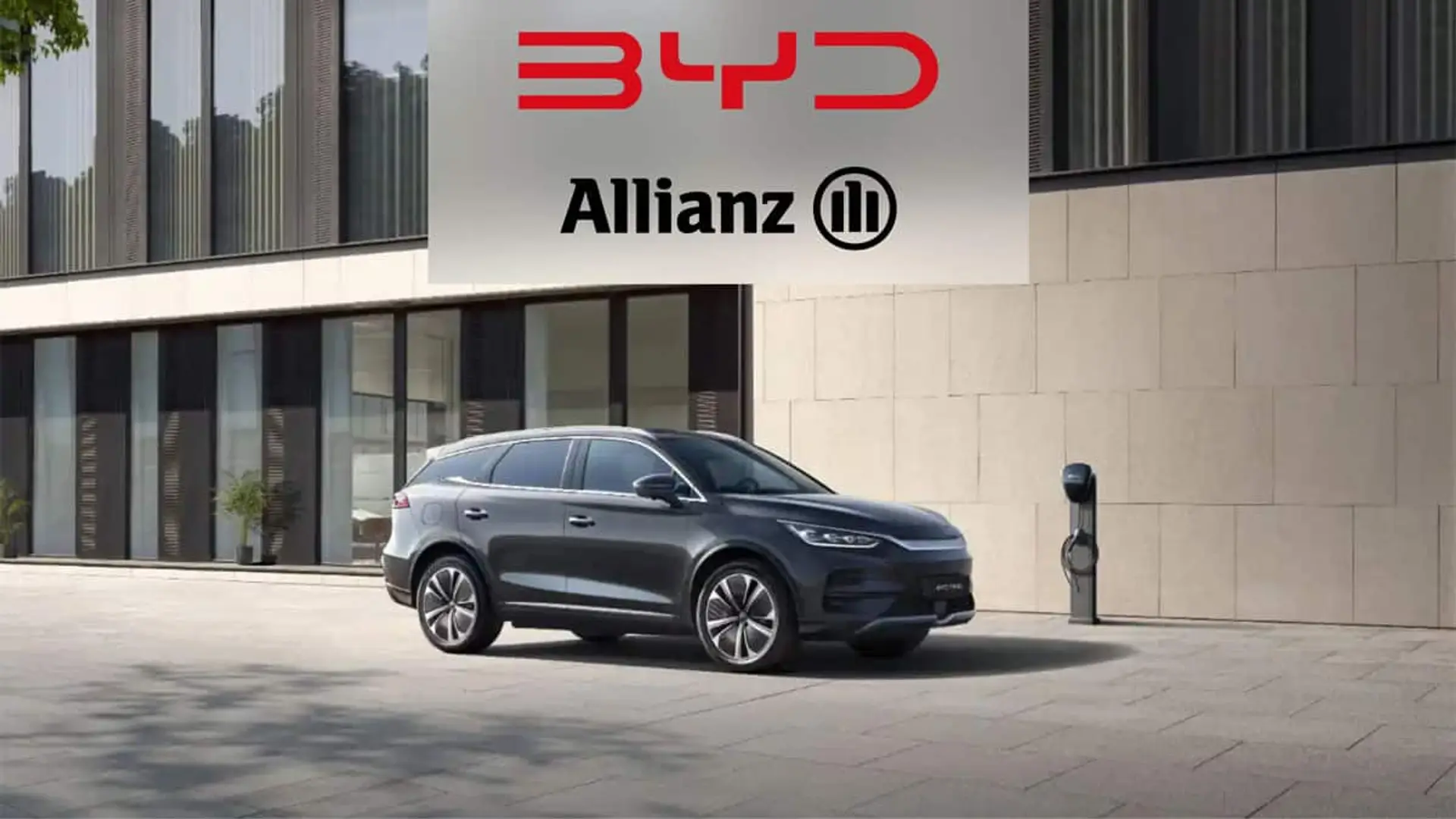 Coche BYD aparcado junto a un punto de carga con el logotipo de Allianz en la parte superior