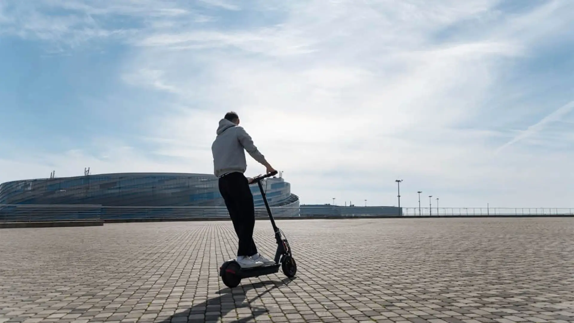 Hombre desplazándose por la ciudad en patinete eléctrico.