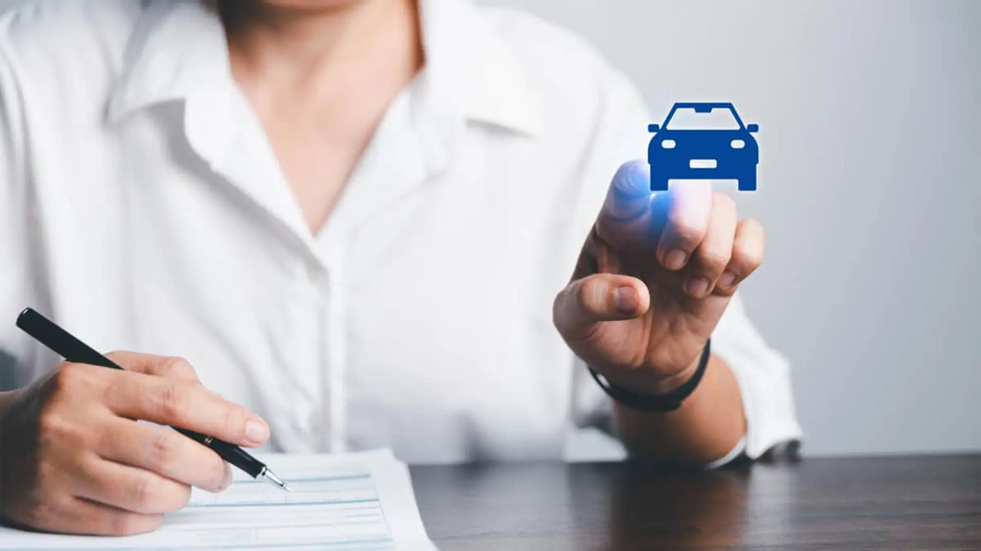 Cambios en el Baremo de Autos: si sufres un accidente en 2026, tu indemnización será más alta Persona firmando contrato de seguro de coche con icono digital de vehículo para trámites online.
