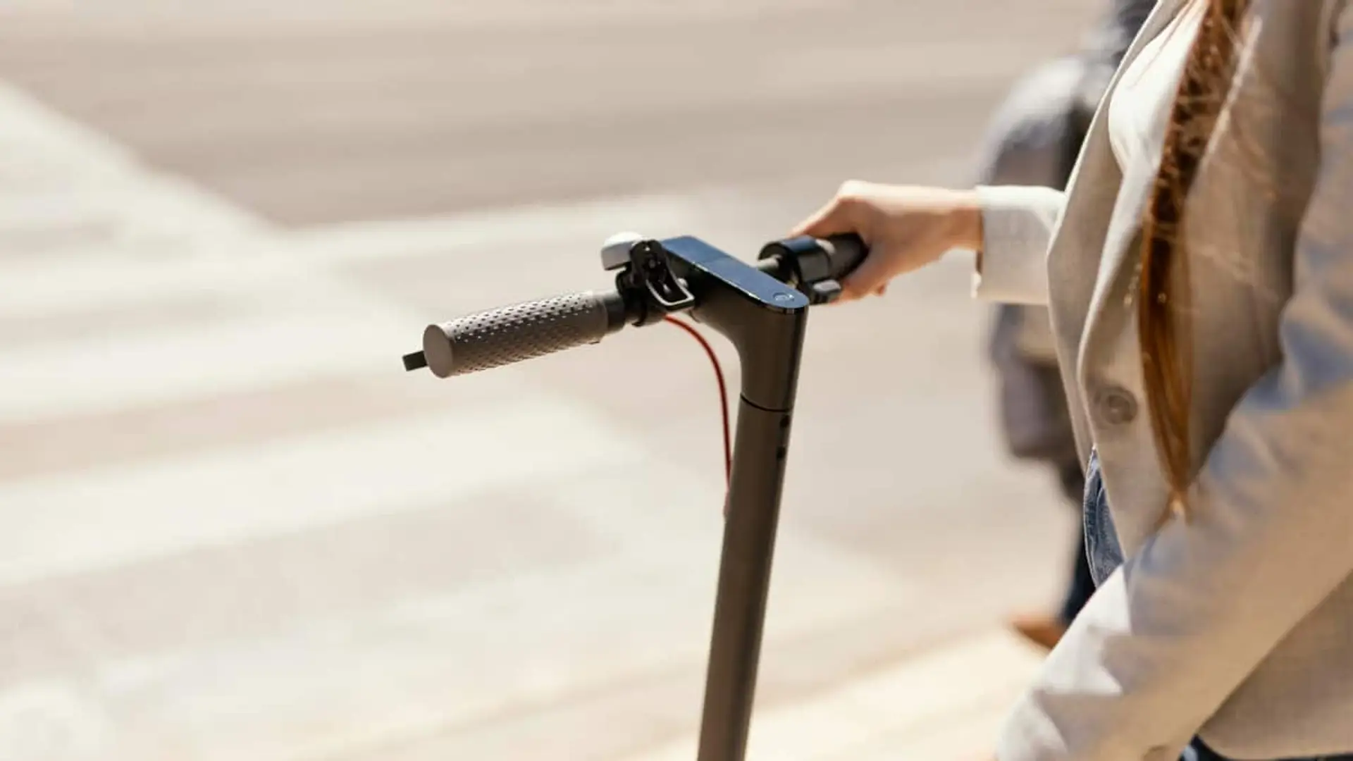 Primer plano del manillar de un patinete eléctrico utilizado para desplazamientos en ciudad.