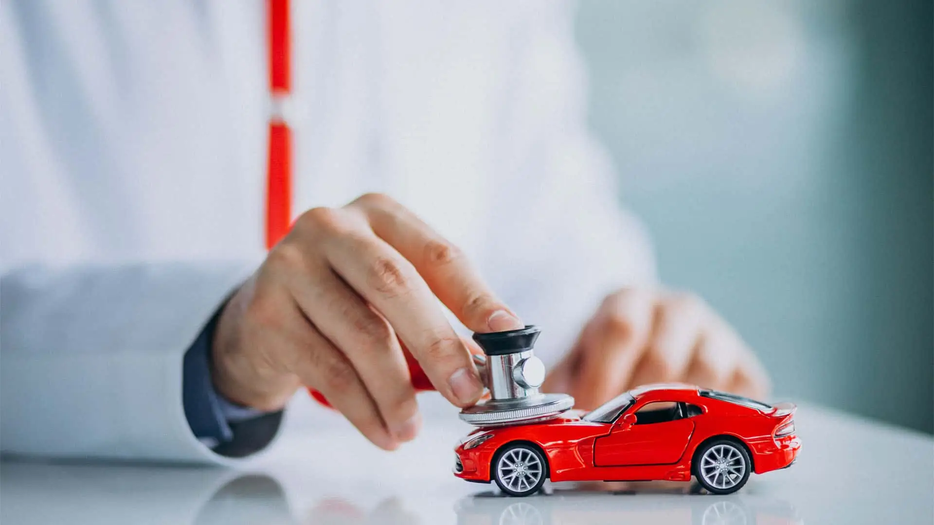 Concepto del seguro de coche: un mecánico revisa un vehículo con un estetoscopio. Mantenimiento, diagnóstico y protección.