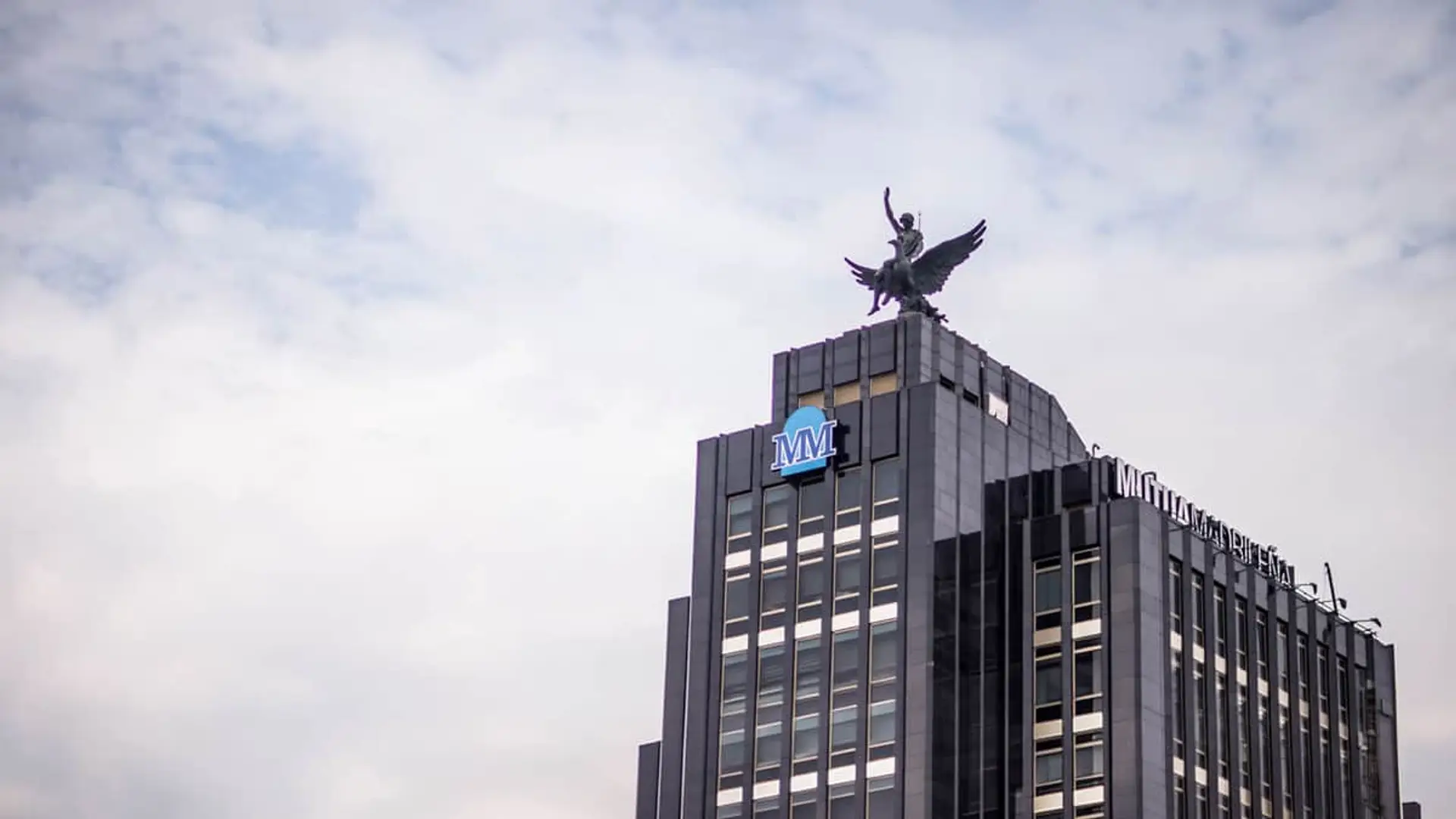 Edificio sede de Mutua Madrileña en Madrid con el logotipo corporativo MM y la emblemática estatua del Fénix.