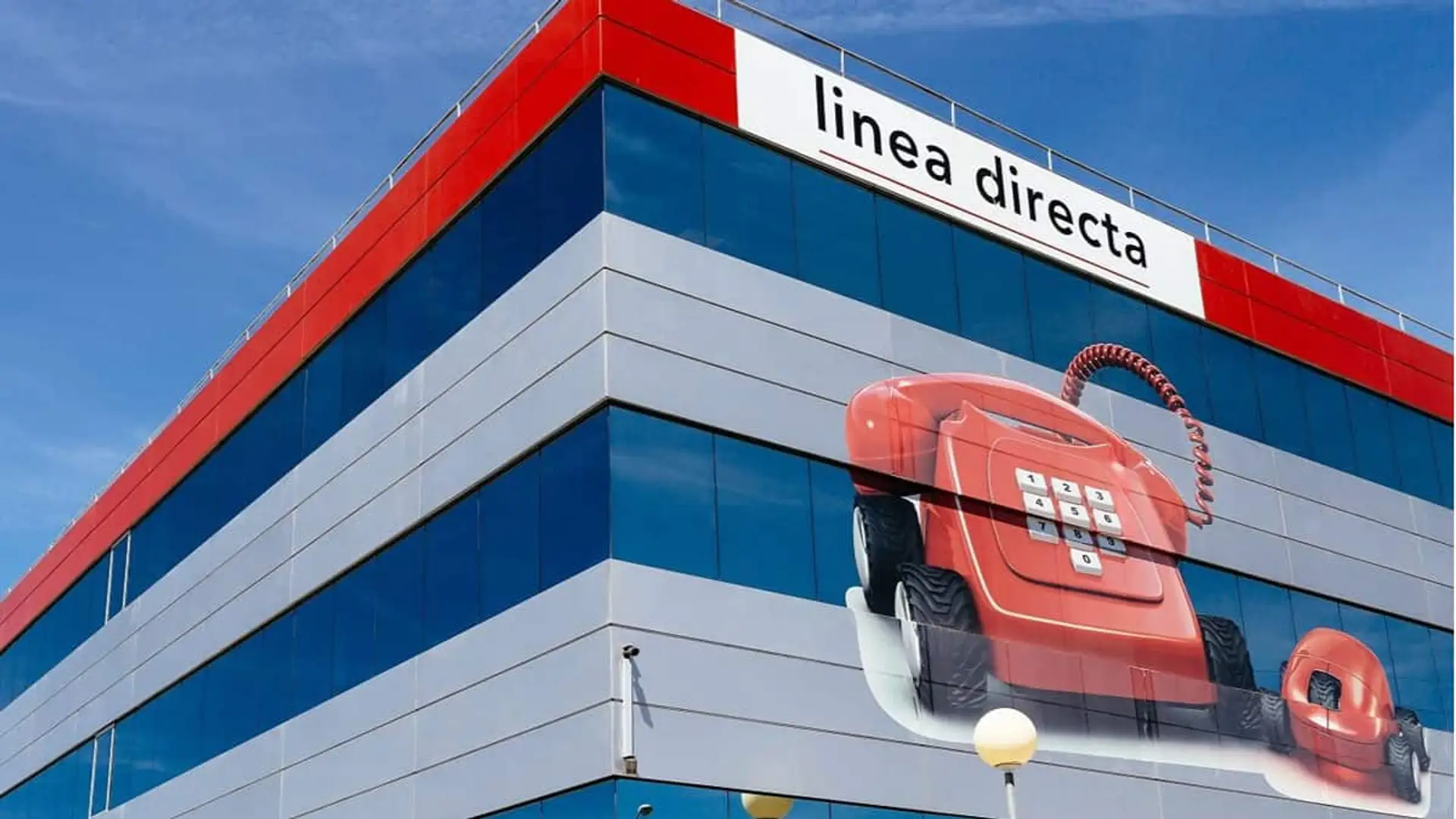 Línea Directa gana casi un 50% más que hace un año y alcanza récord histórico de clientes Sede de Línea Directa con sus teléfonos rojos sobreimpresionados en la fachada.