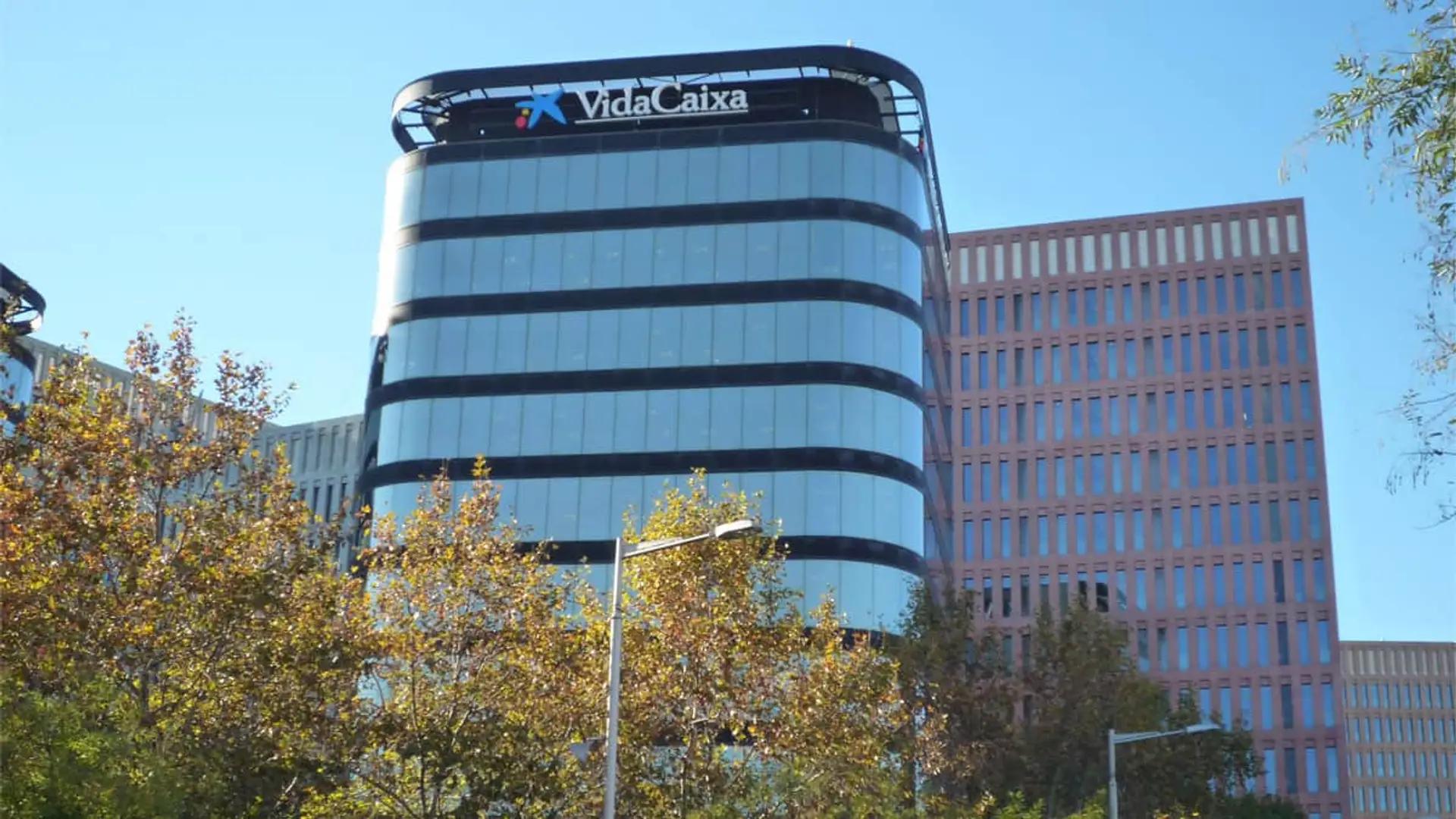 Sede de VidaCaixa: fachada del edificio de oficinas con el logotipo corporativo bajo un cielo azul.