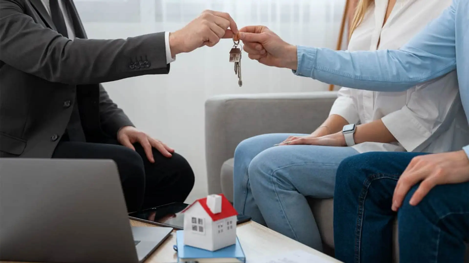 Onlygal lanza nuevas coberturas legales para propietarios: así son Compraventa Asegurada y Alquiler 360 Agente inmobiliario entrega las llaves de una casa a una pareja.