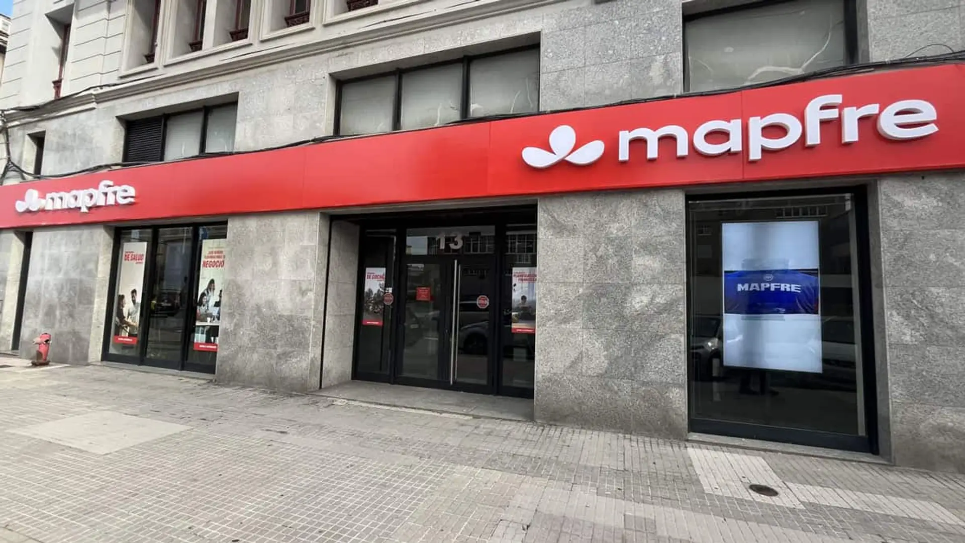 Mapfre gana un 11,5% más hasta septiembre pese al terremoto de Colombia, que le cuesta 83 millones Fachada de una oficina de seguros Mapfre con rótulos rojos, puertas de cristal y escaparates.