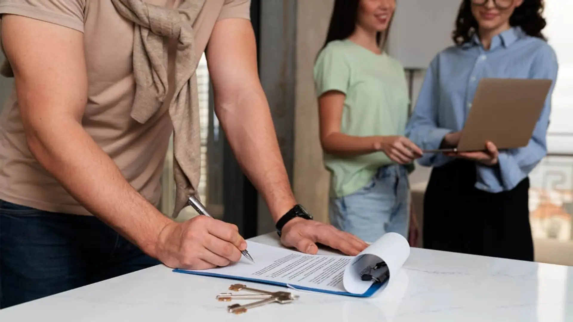 ¿Es legal que el inquilino asuma el seguro de impago del alquiler? Esto dicen los jueces Hombre firmando el contrato de compra o alquiler de una vivienda frente a la agente inmobiliaria.