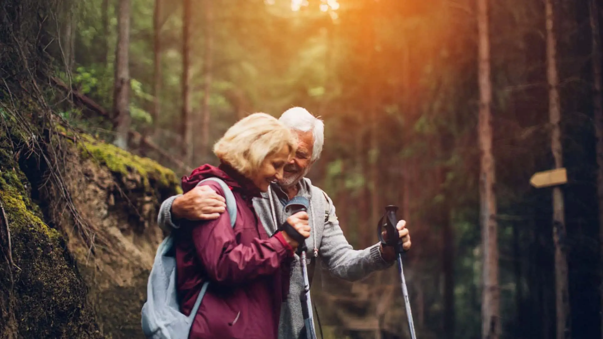 Pareja de jubilados practicando senderismo en el bosque.