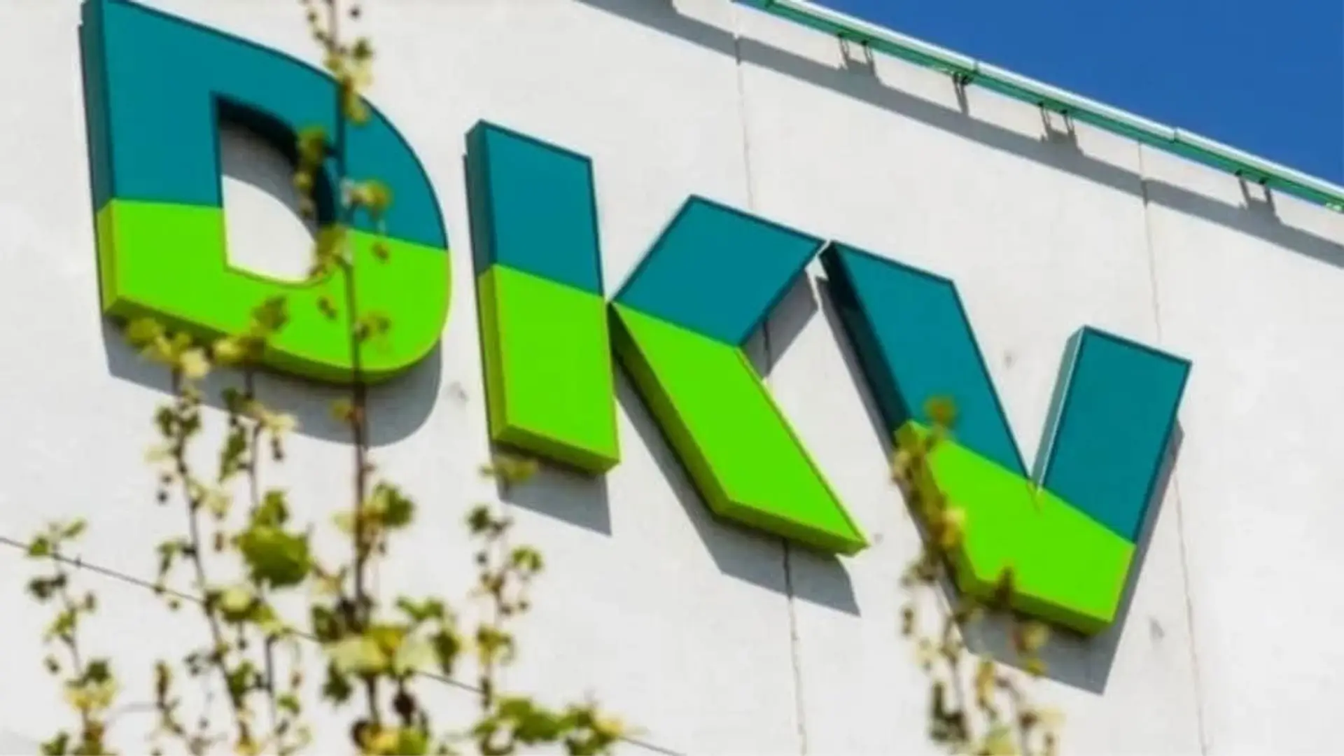 DKV nota la pérdida de pacientes de Muface: se reorganiza para controlar gastos y mejorar la eficiencia Rótulo con el logo de la compañía de seguros DKV en la fachada de una de sus oficinas corporativas.