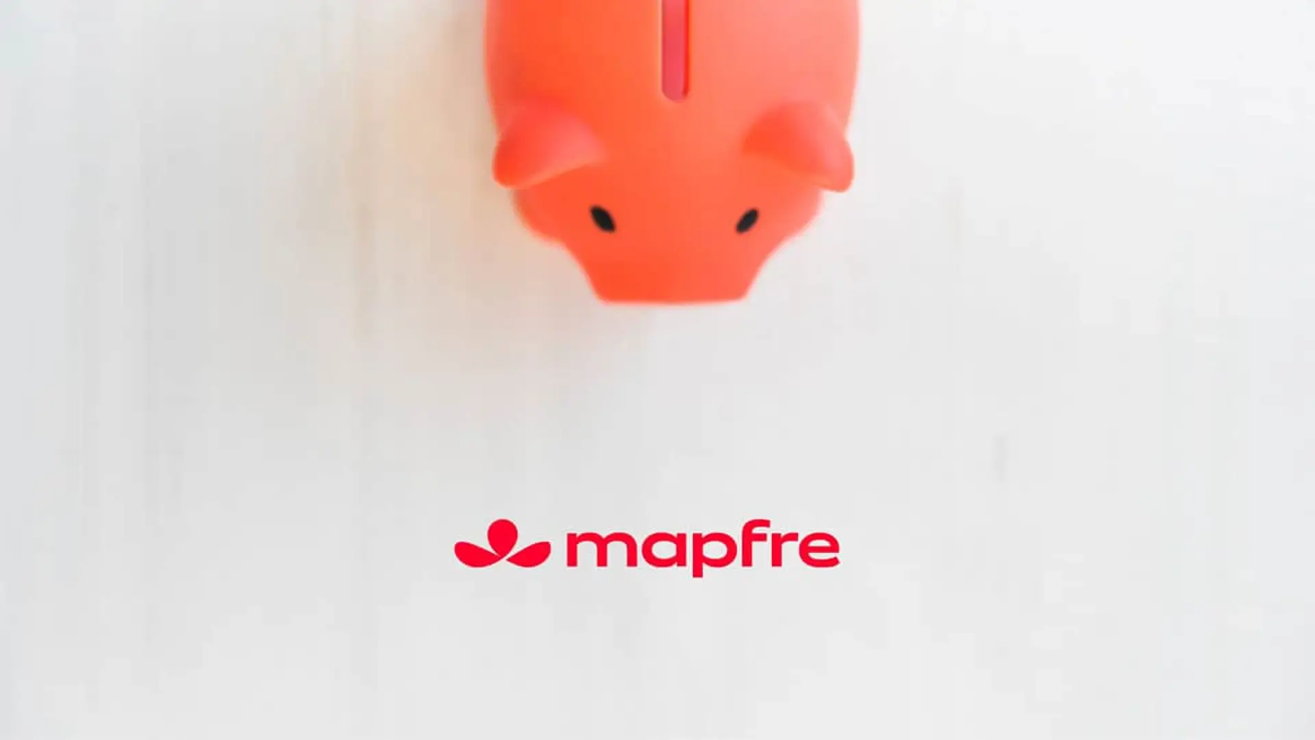 Hucha de cerdito roja junto al logotipo de Mapfre para representar su nuevo seguro de ahorro garantizado.