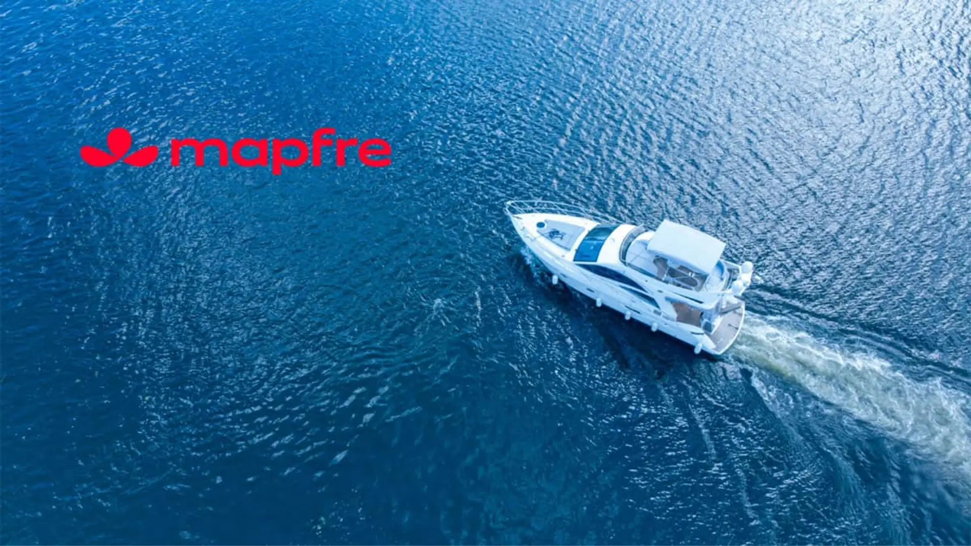 Mapfre rediseña su seguro de barcos: coberturas flexibles y lo que tu puerto ya te exige Vista aérea de un yate navegando junto al logotipo de Mapfre para representar los seguros de embarcaciones de recreo.