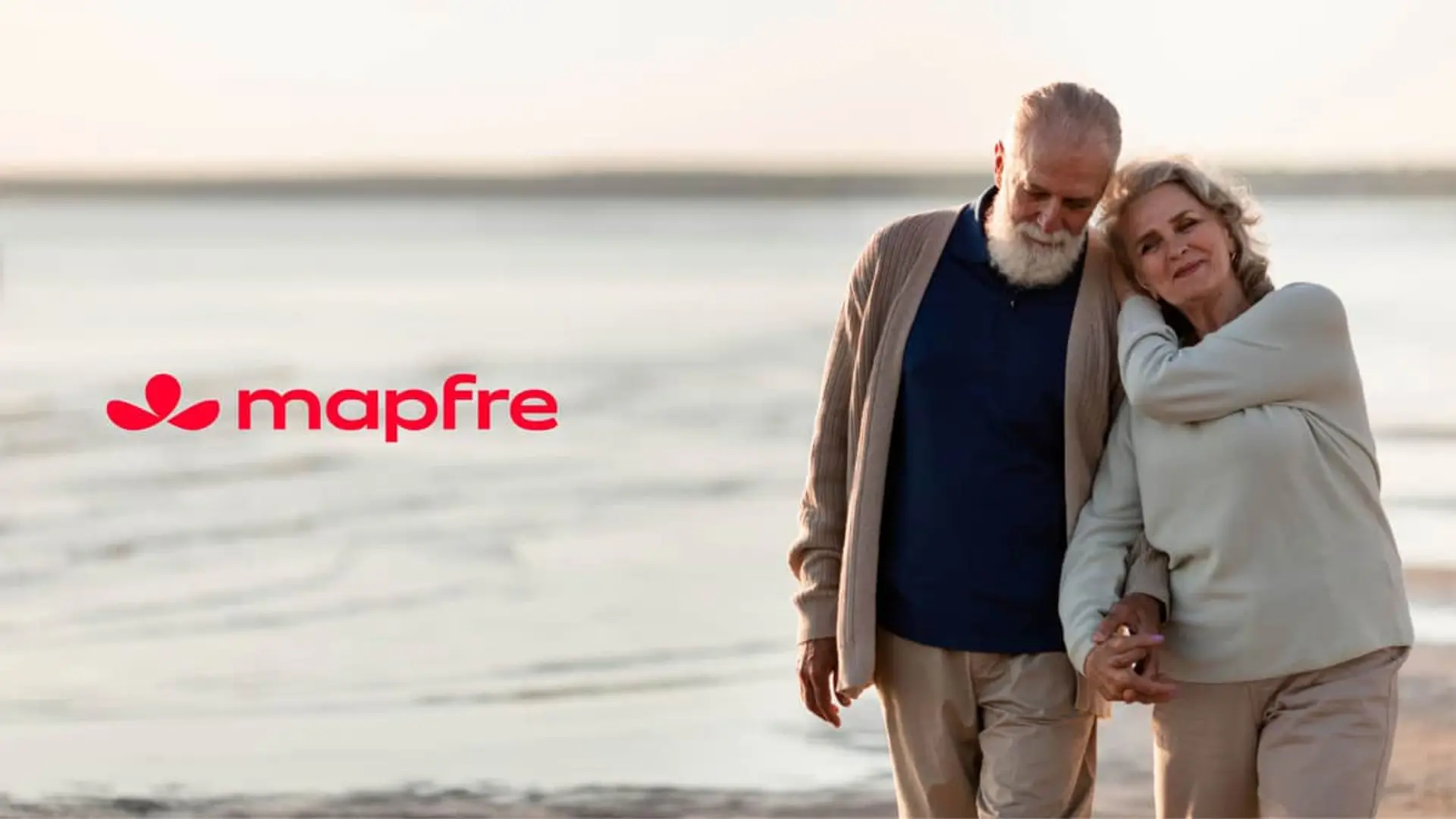 Mapfre lanza un seguro de vida para mayores sin edad límite y con servicios de asistencia incluidos Pareja mayor paseando por la playa al atardecer simbolizando la jubilación tranquila con Mapfre.