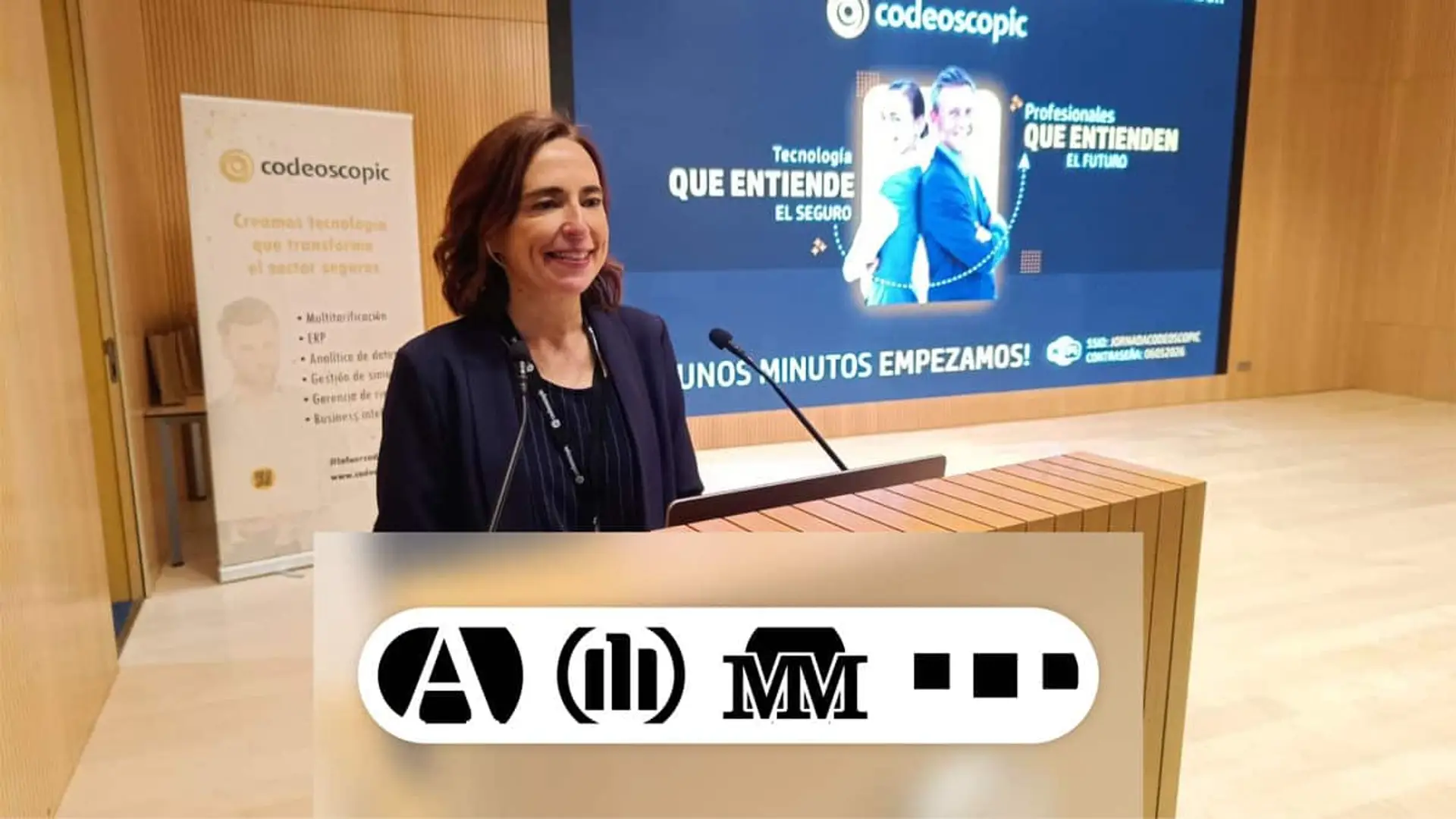 Qué han hecho Mutua Madrileña, Allianz, Santalucía y SegurCaixa Adeslas para ganar los Premios Codeoscopic 2026 Mujer hablando en un atril durante un evento de Codeoscopic con varios logotipos de las aseguradoras Allianz, Mutua Madrileña, Adeslas y Santalucía.