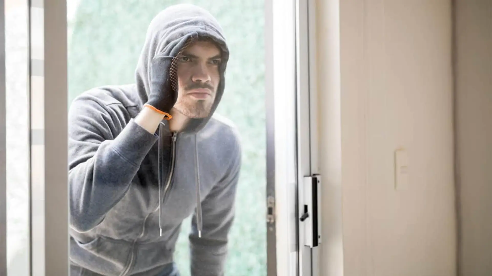 El seguro de hogar de Pelayo se blinda frente a la okupación: esta es su nueva cobertura clave Okupa con sudadera intentando entrar en una casa.