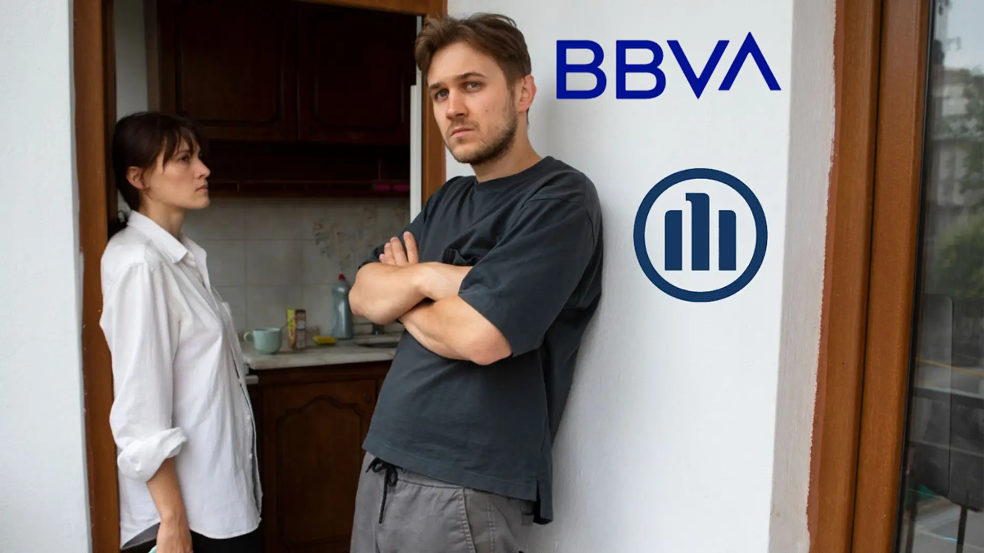 Hombre y mujer en la puerta de una vivienda con los logotipos de BBVA y Allianz en la pared