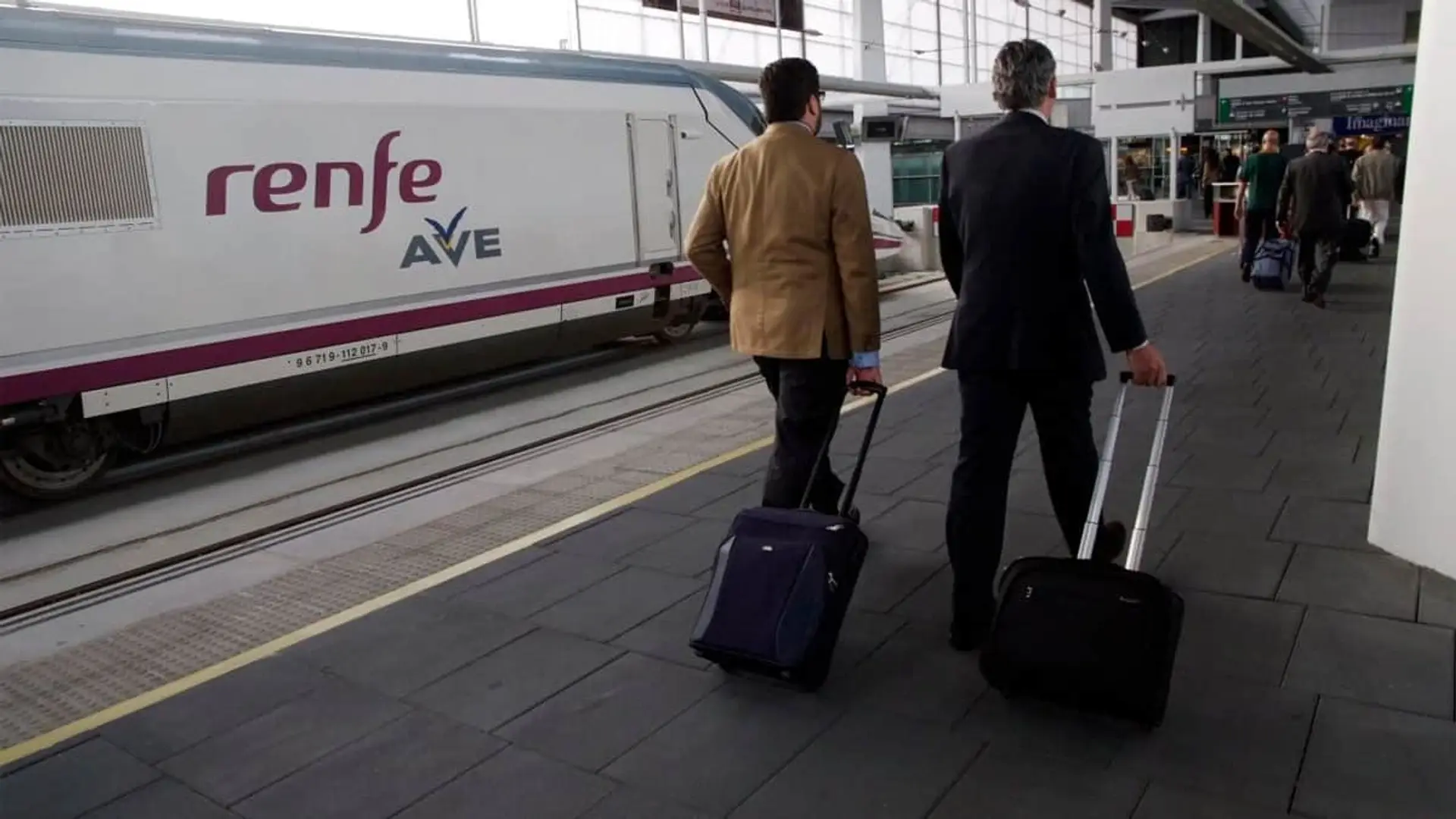 Qué seguros se activan tras un accidente ferroviario como el de Adamuz y qué indemnizaciones pueden reclamar los viajeros Pasajeros caminando con maletas por el andén junto a un tren de alta velocidad Renfe AVE.