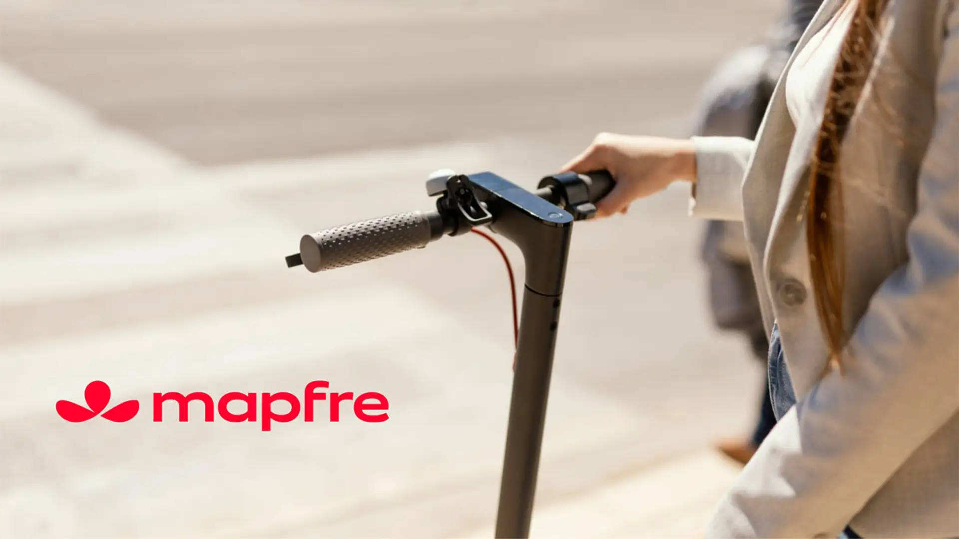 Logotipo de Mapfre junto al manillar de un patinete eléctrico para representar seguros de movilidad urbana segura.