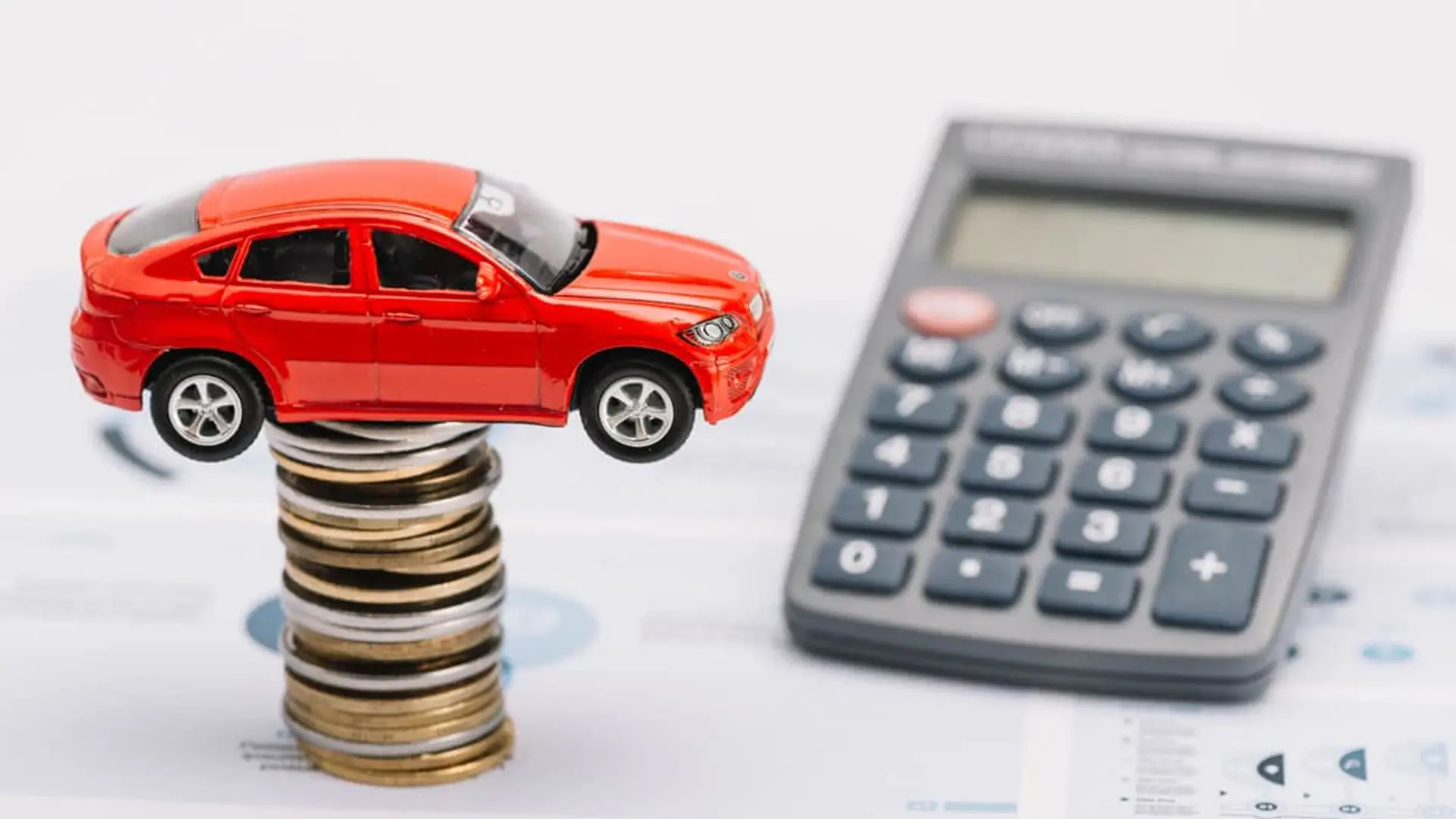 Así cambia el precio del seguro de coche en 2025: asegurar un vehículo cuesta casi el doble en Ceuta que en Cáceres Coche sobre monedas y una calculadora para planificar el presupuesto.