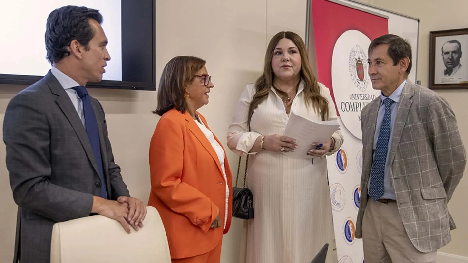 Representantes y académicos en un acto institucional en la Universidad Complutense. Ponentes conversando durante una conferencia.