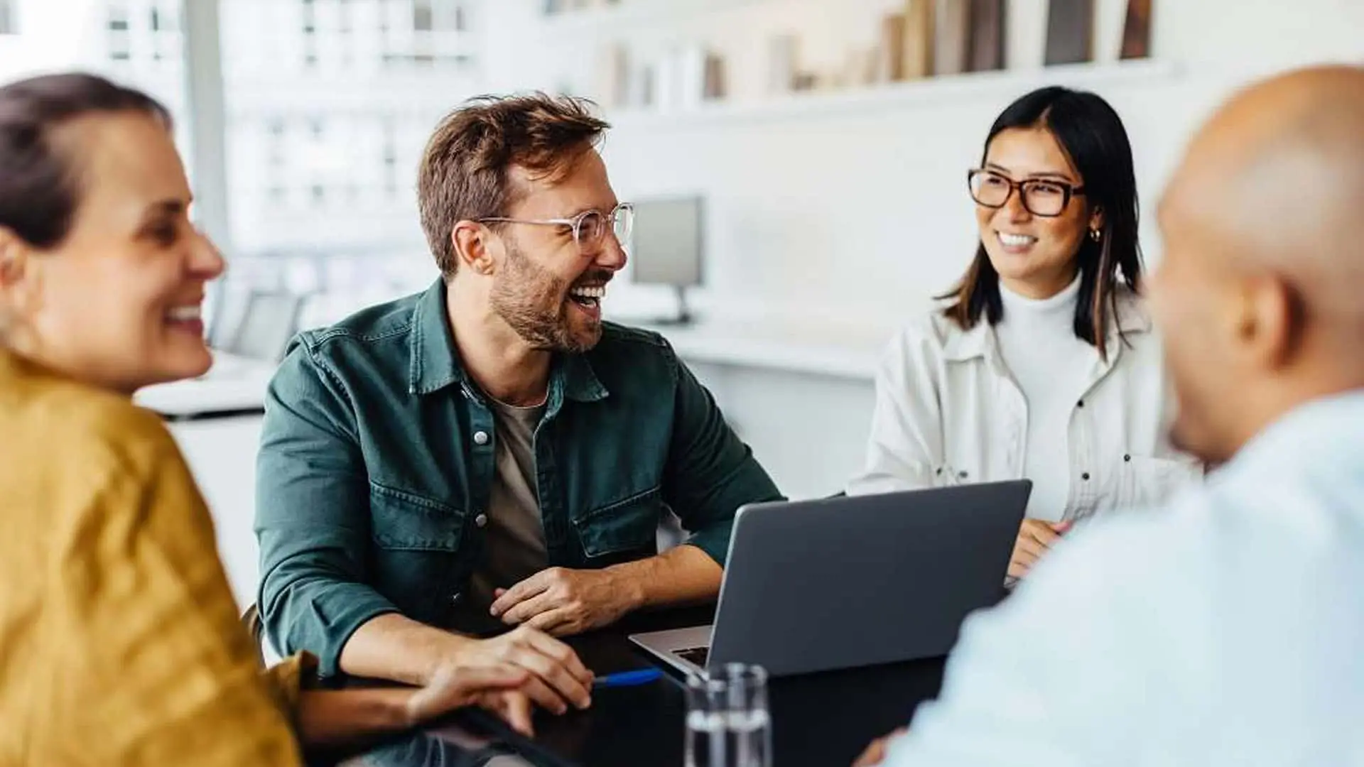 Equipo de profesionales diversos en una reunión de trabajo productiva y con buen ambiente. Colaboración y cultura de empresa.