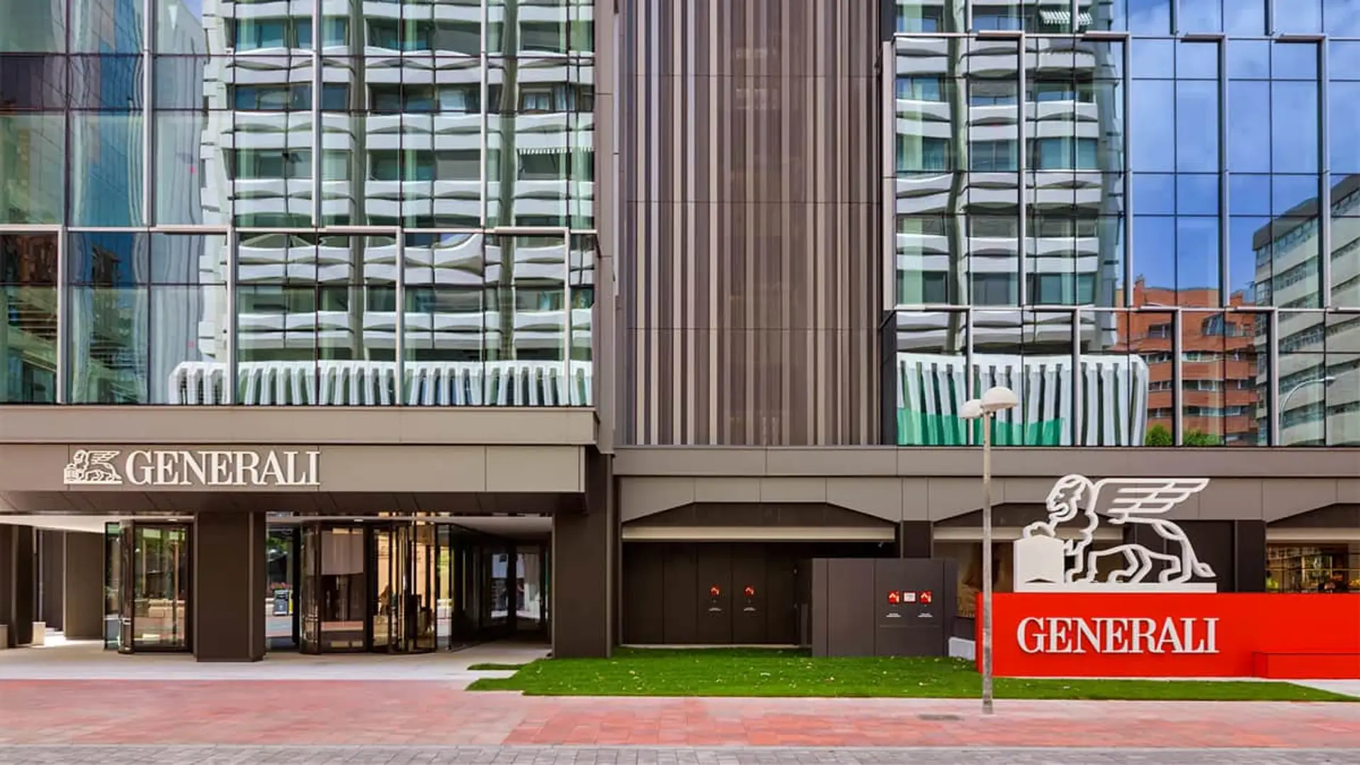 Fachada de la sede corporativa de Generali Seguros con el logotipo oficial del león alado en la entrada de la oficina.
