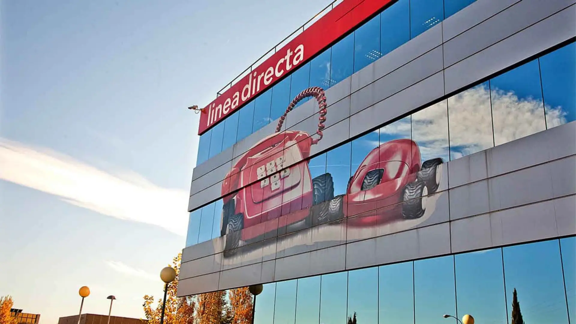 Línea Directa arrasa en 2025: gana un 33% más y suma 300.000 clientes Fachada del edificio de la sede de Línea Directa con el emblemático logo del teléfono rojo sobre ventanales de cristal.