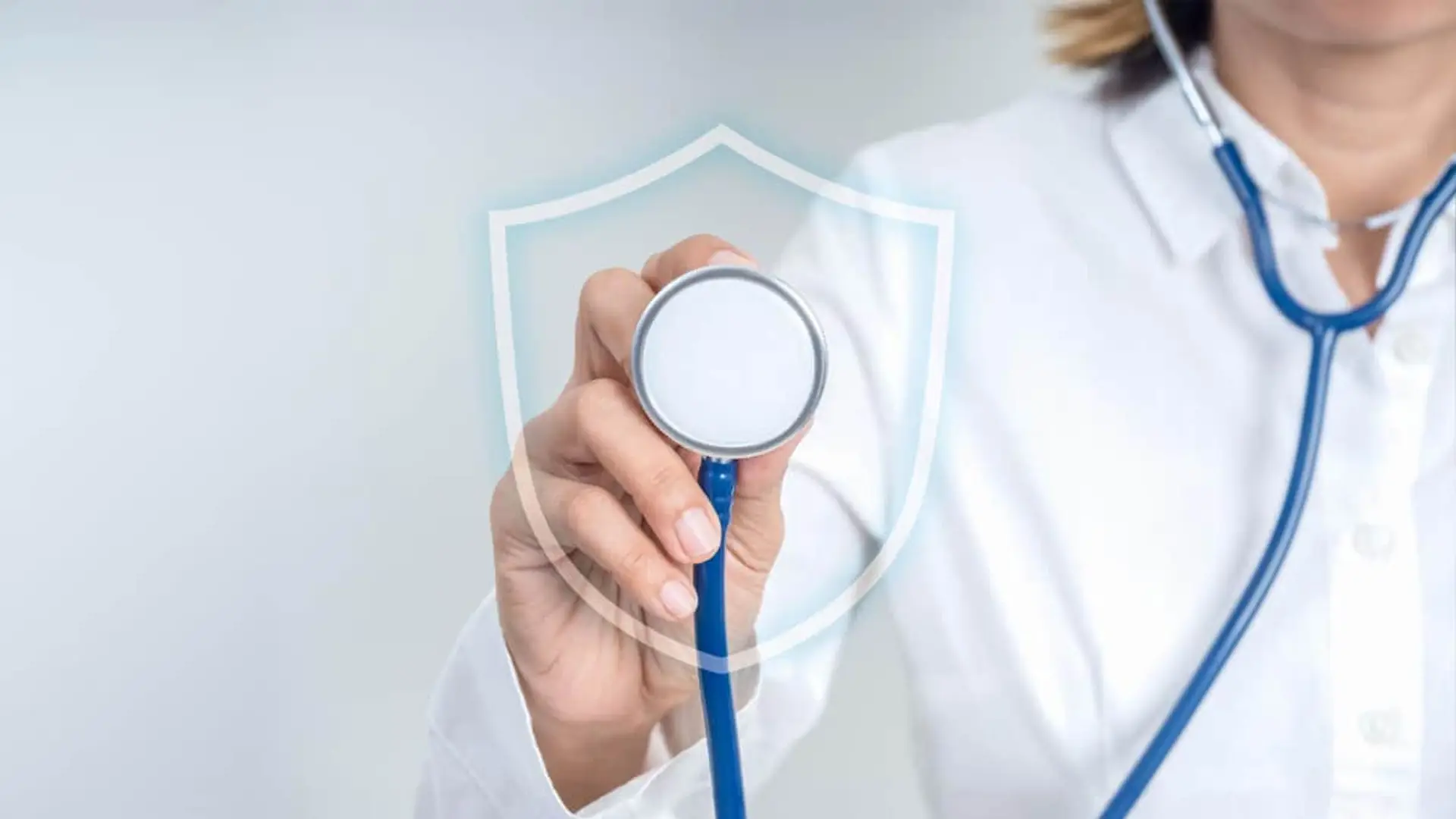 El seguro de salud hace balance y avisa: crecerá en 2026, pero afronta retos clave Mano de médico sosteniendo estetoscopio con un escudo de protección virtual simbolizando seguro de salud.