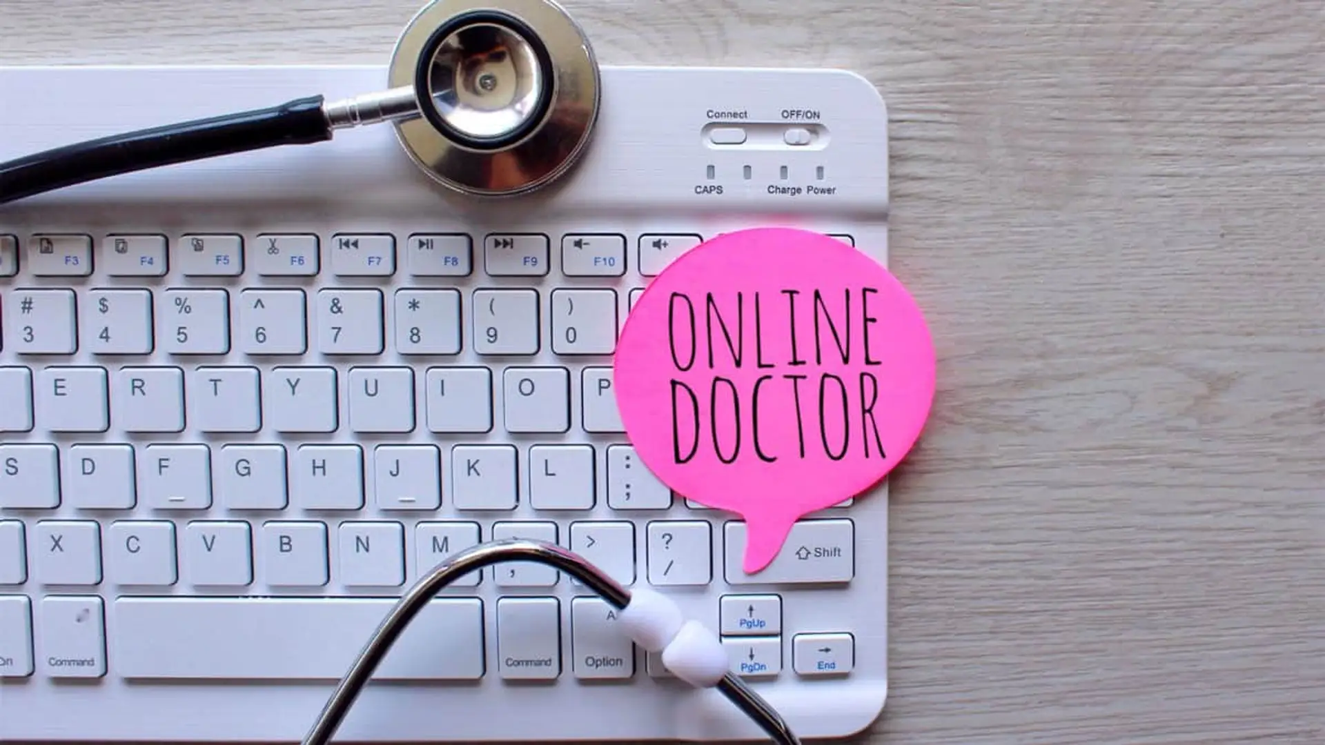 Concepto de consulta médica online con fonendoscopio sobre teclado blanco