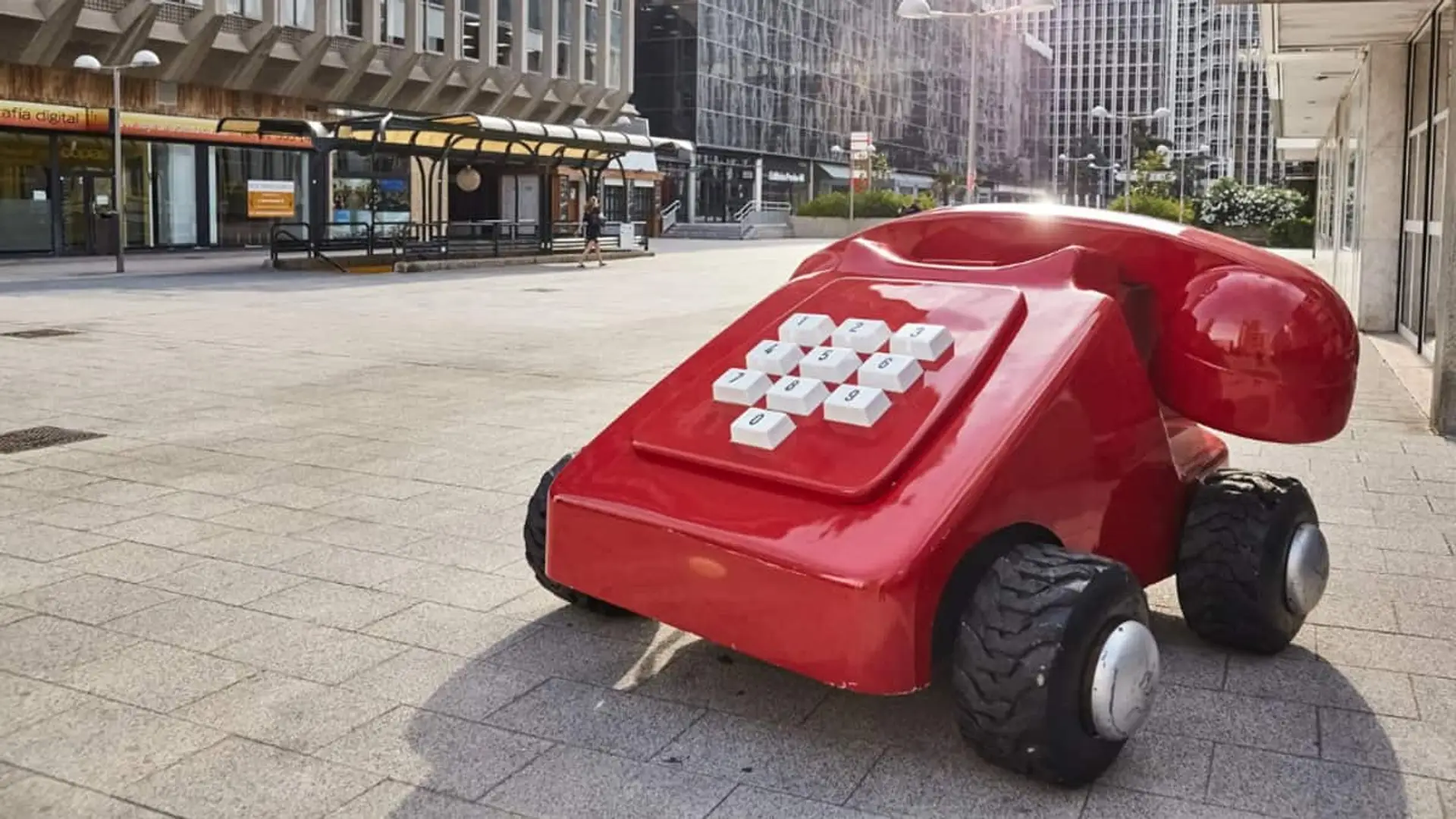 Escultura del icónico teléfono rojo de Línea Directa situada en una calle urbana