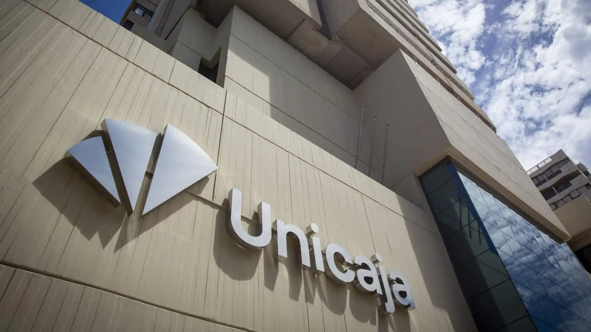 Fachada de la sede de Unicaja con el logotipo del banco en un edificio moderno.