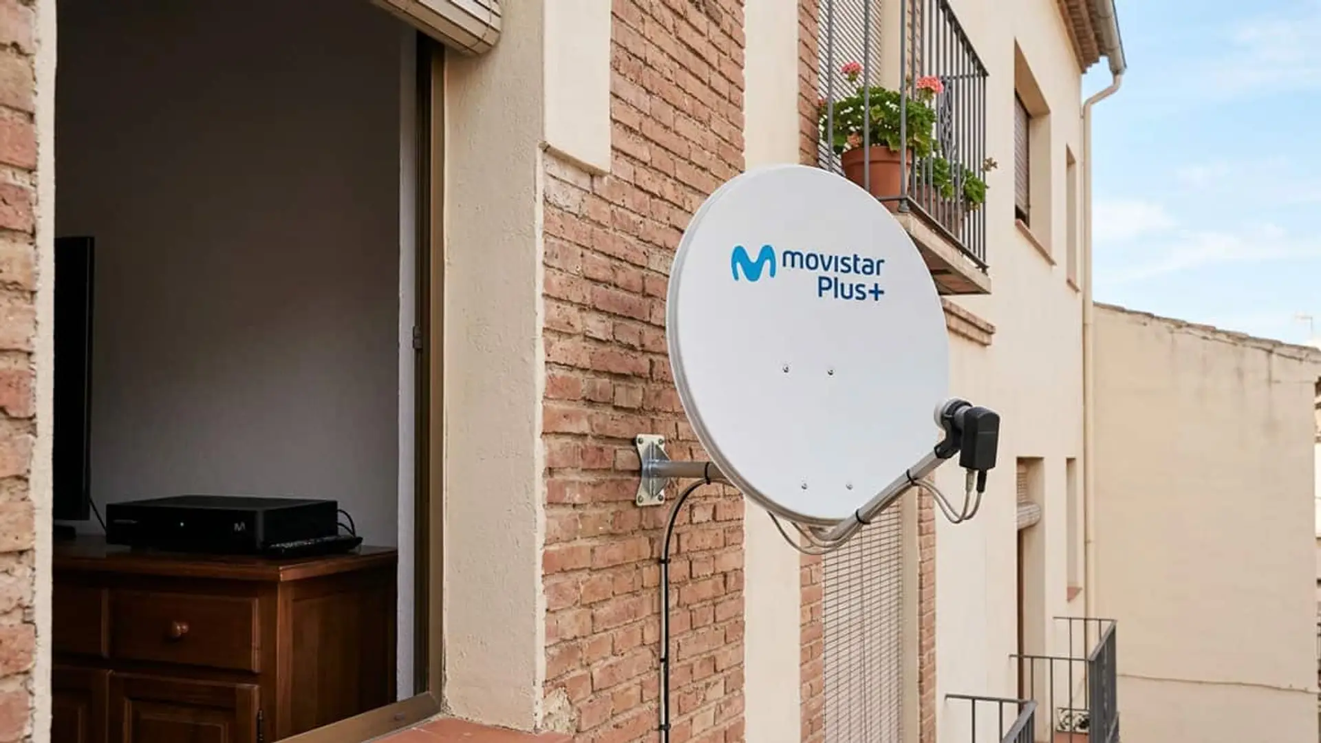 Antena parabólica de Movistar Plus+ instalada en la fachada de una vivienda junto a un descodificador