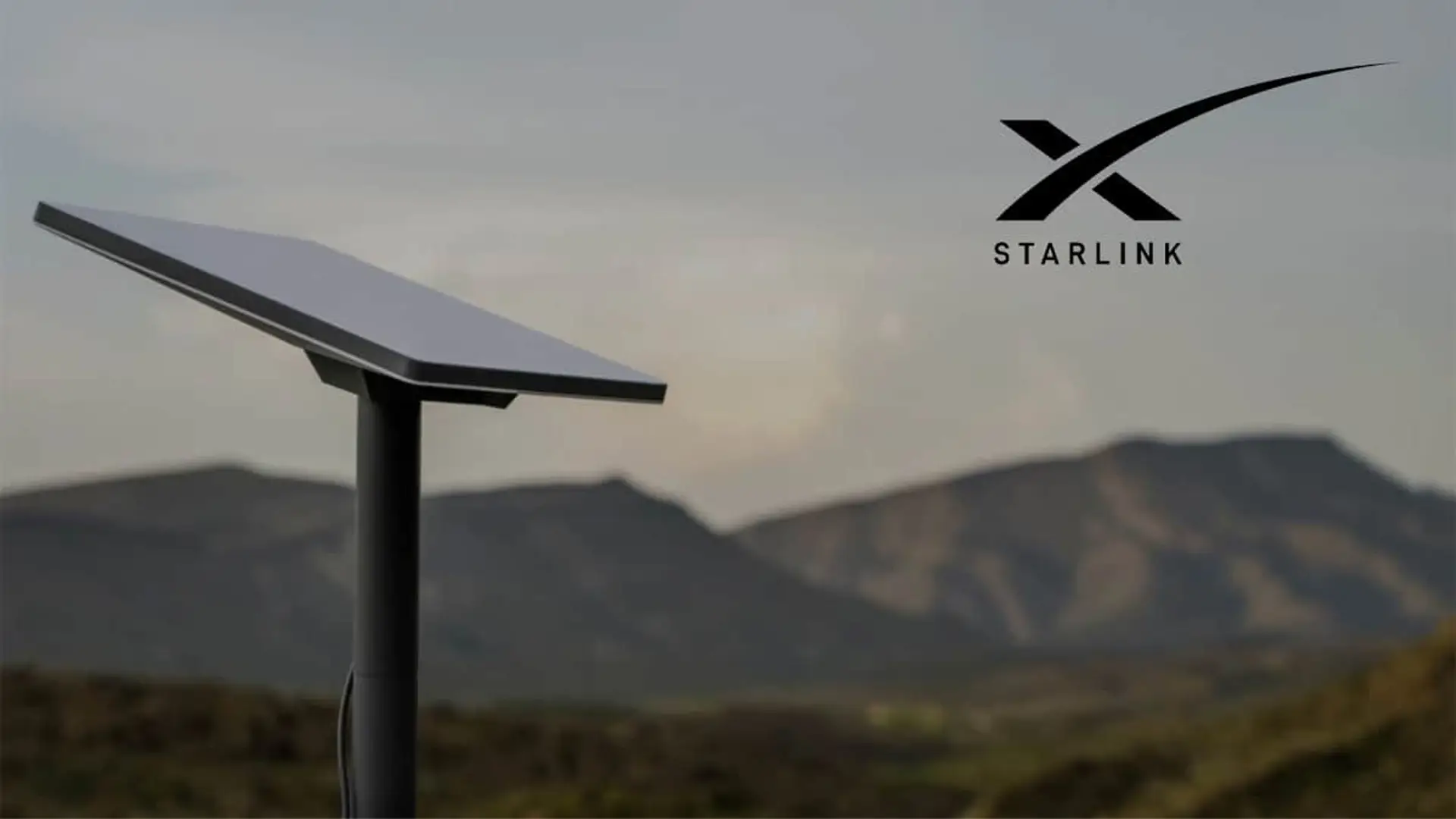 El regalo inesperado de Starlink: Elon Musk te da un año de conexión gratis si cumples este requisito Antena de Starlink con logotipo frente a montañas para conexión a internet por satélite en entornos rurales.