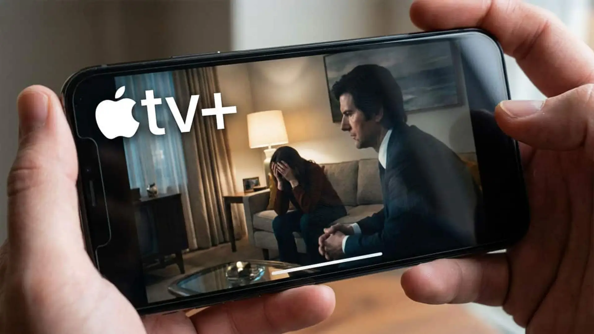 Todos los estrenos de Apple TV en enero de 2026: vuelven series muy esperadas Manos sosteniendo un smartphone con Apple TV+ en pantalla, mostrando una escena dramática de una serie.