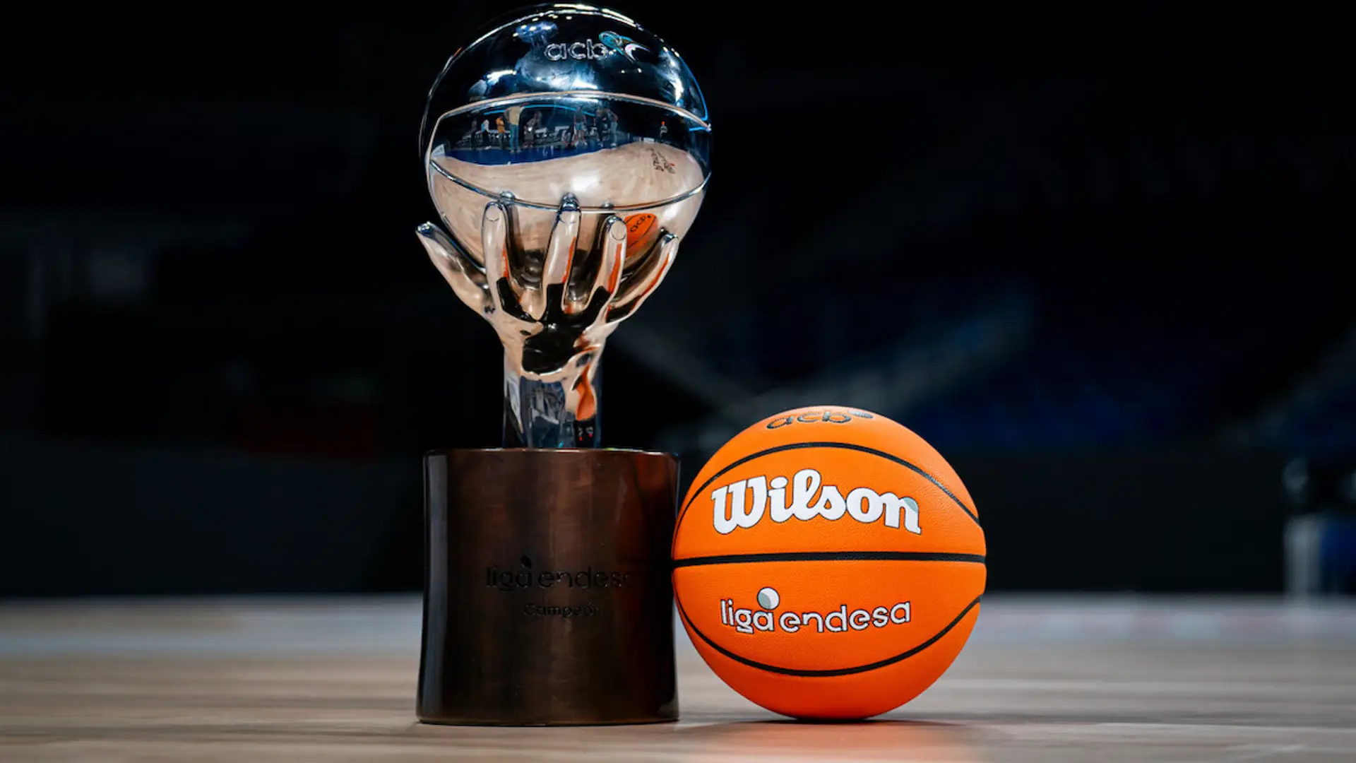 Trofeo de campeón de la Liga Endesa junto al balón oficial Wilson en el centro de una cancha de baloncesto.