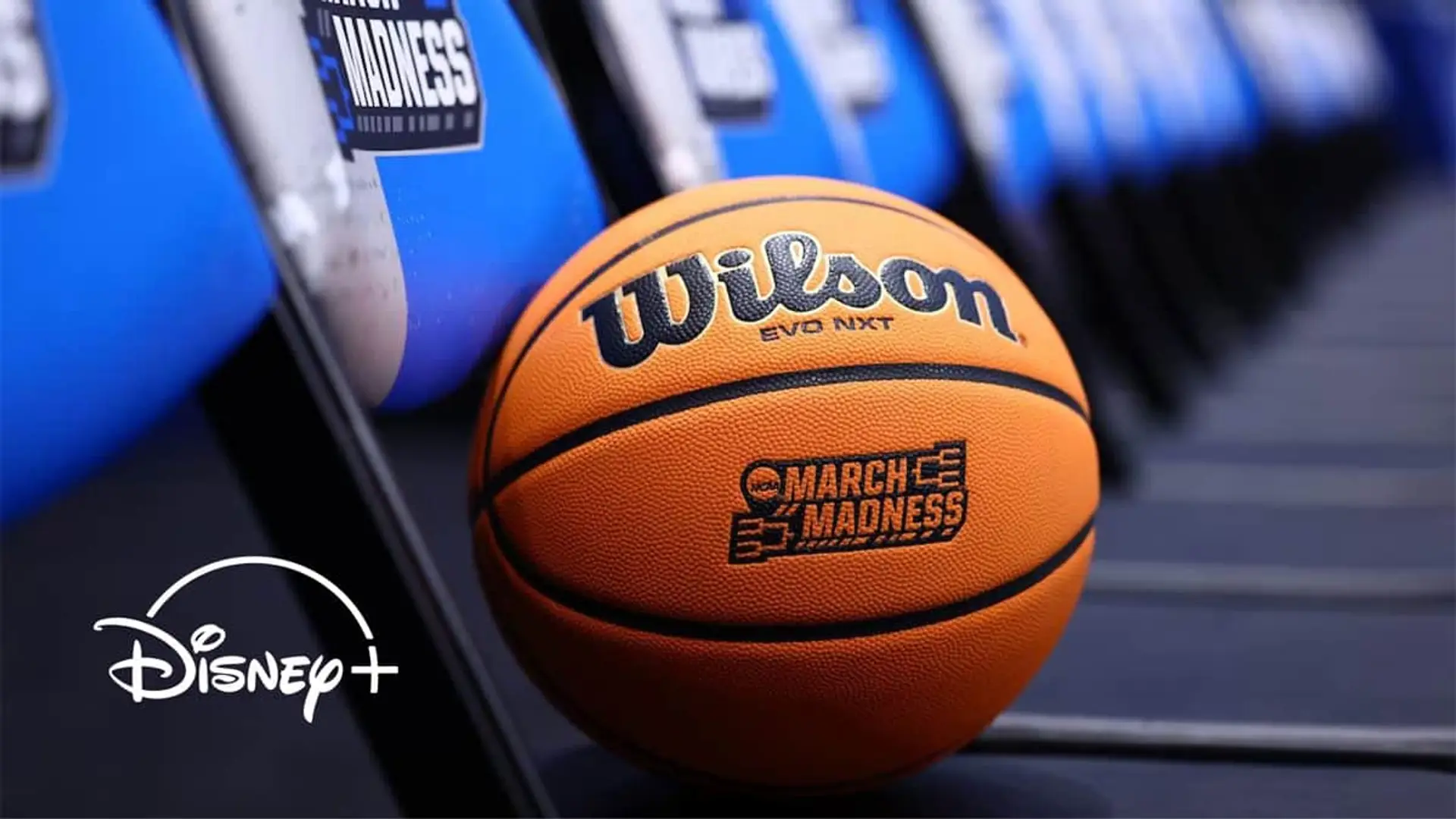 Balón de baloncesto Wilson March Madness junto al logotipo de Disney Plus para ver deportes universitarios en streaming.