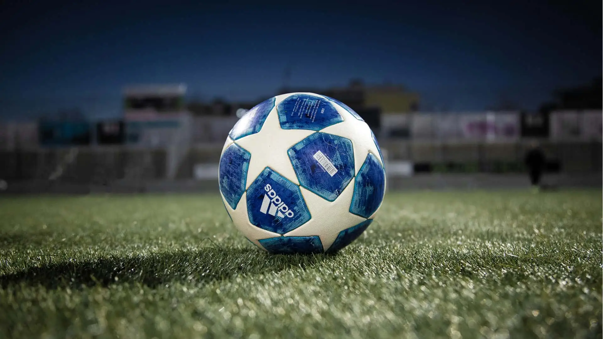 Balón oficial Adidas de la Champions League sobre el césped de un estadio.