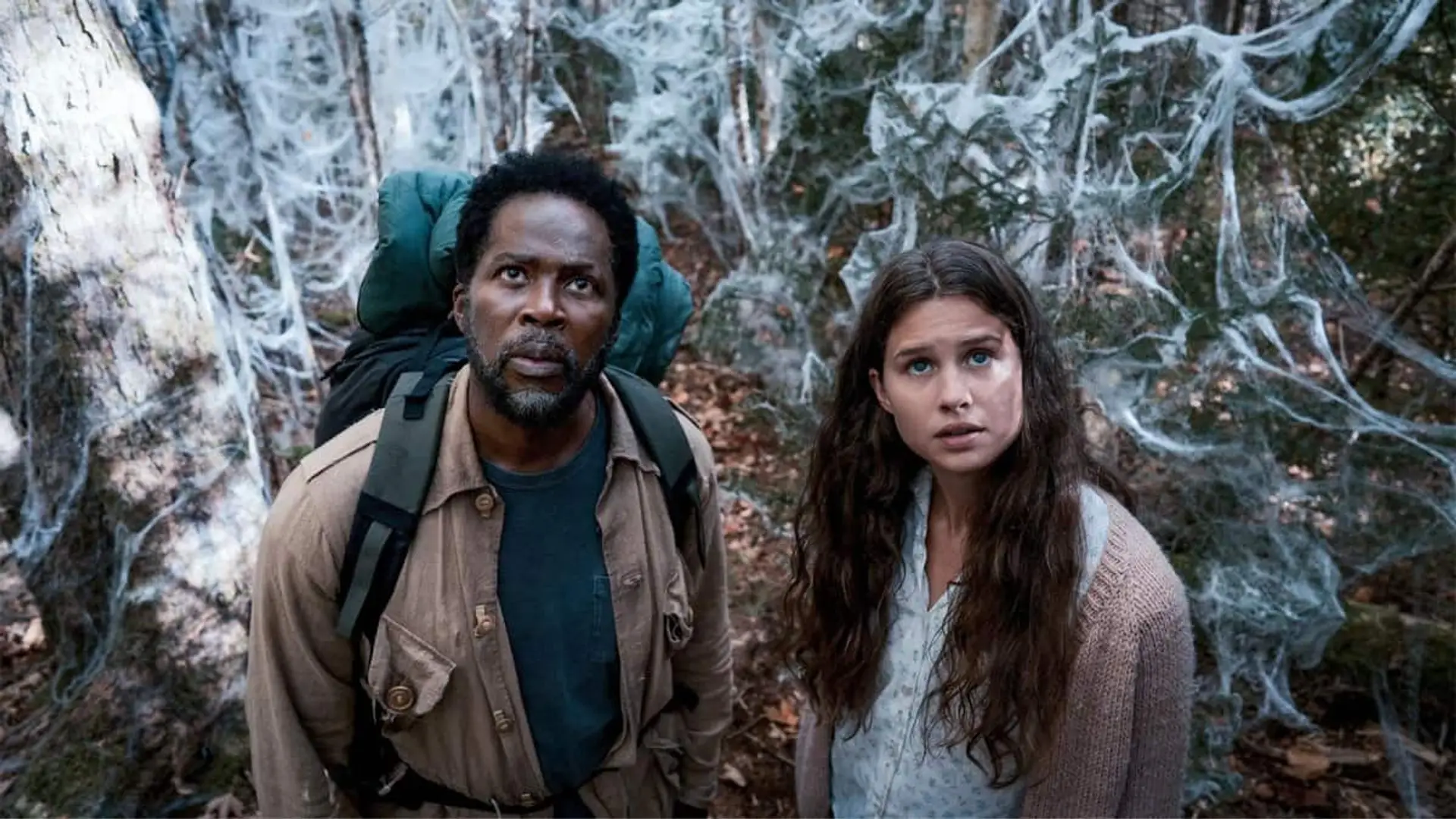 Boyd y Sara, personajes de From, en un bosque rodeados de telarañas