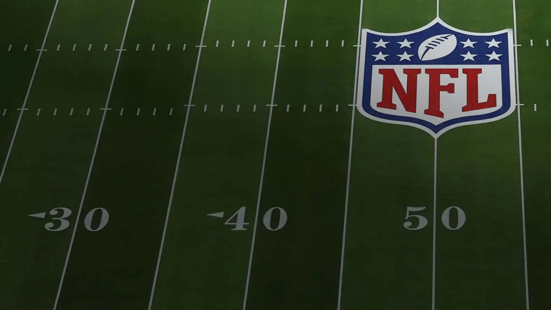 Dónde ver la NFL 2025/26 en España: canales de TV, precios y fechas del fútbol americano Campo de fútbol americano con el logotipo de la NFL pintado sobre el césped.