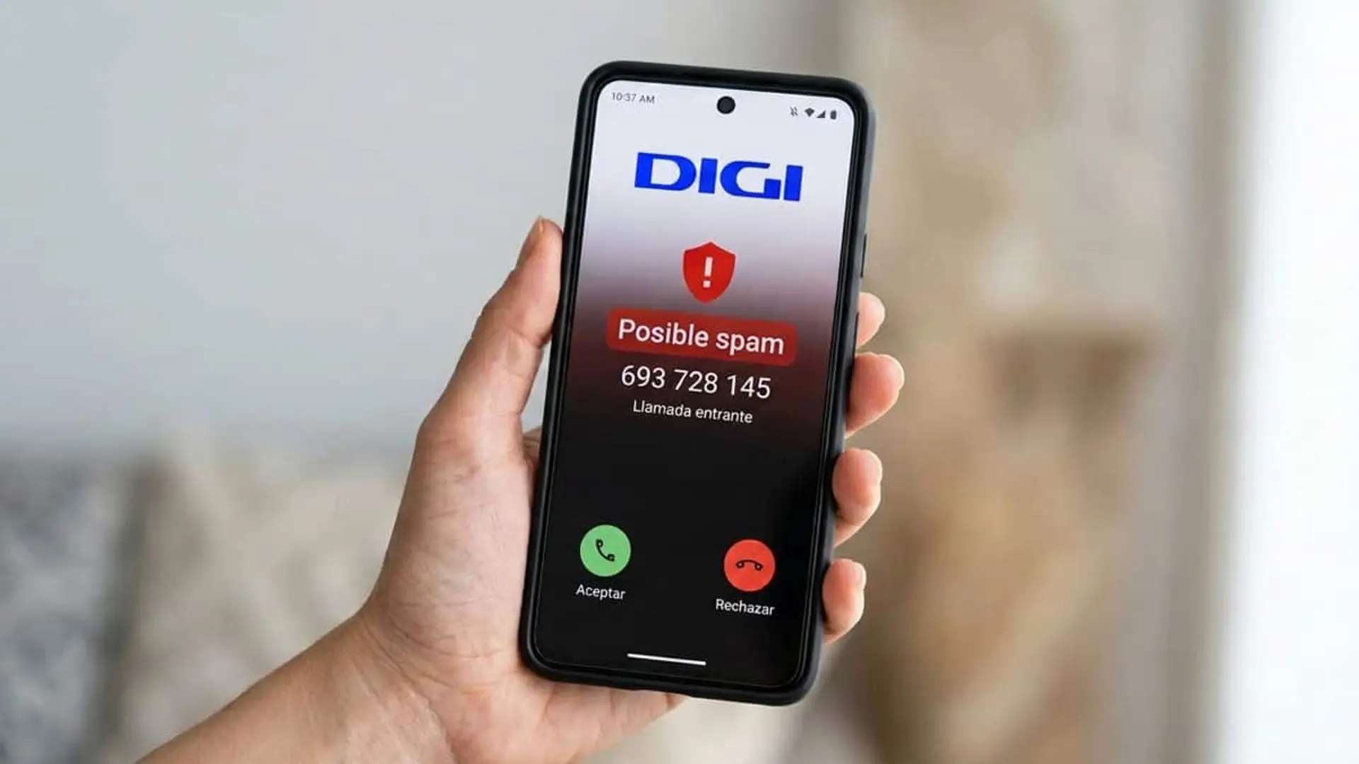 Mano sosteniendo un teléfono móvil con el logotipo de DIGI y un aviso de posible spam en una llamada entrante