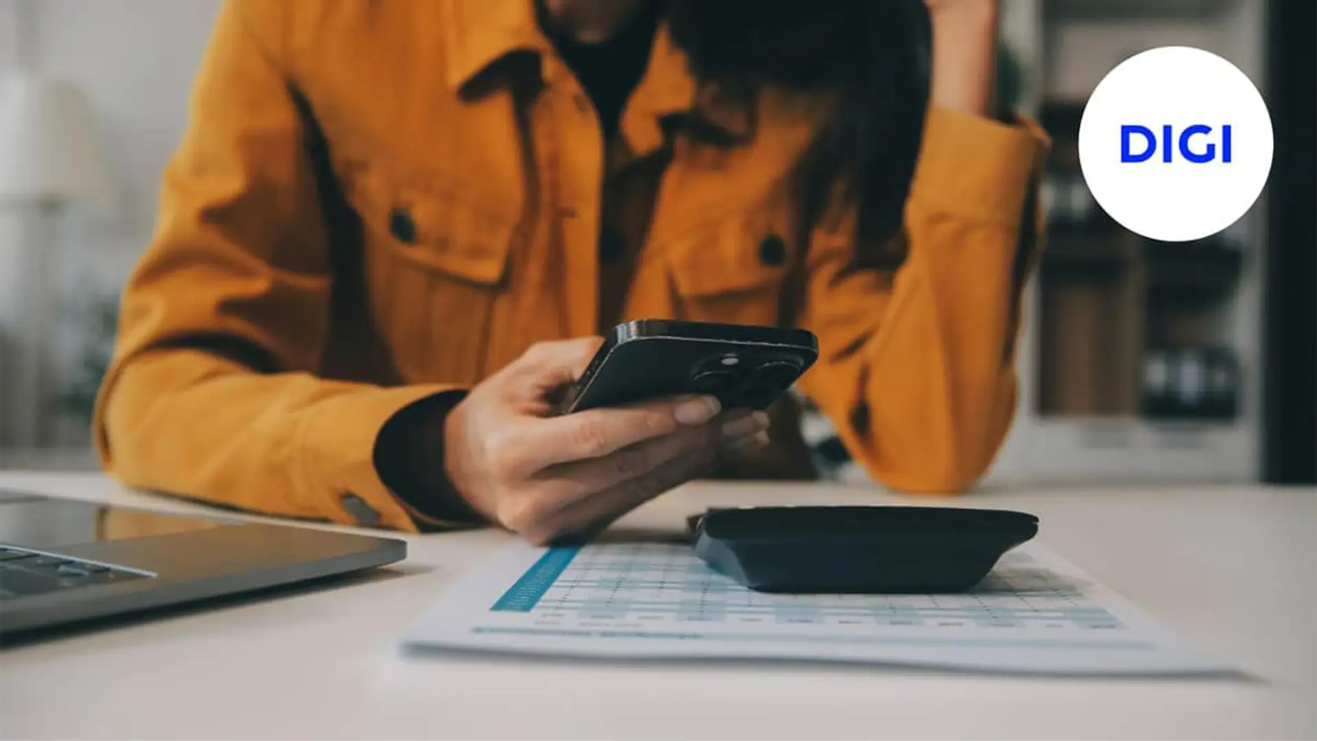 ¿DIGI te ha emitido una factura demasiado baja en noviembre? Este es el motivo por el que ves un precio menor Clienta calculando ahorro en su factura de fibra y móvil DIGI con calculadora y smartphone.