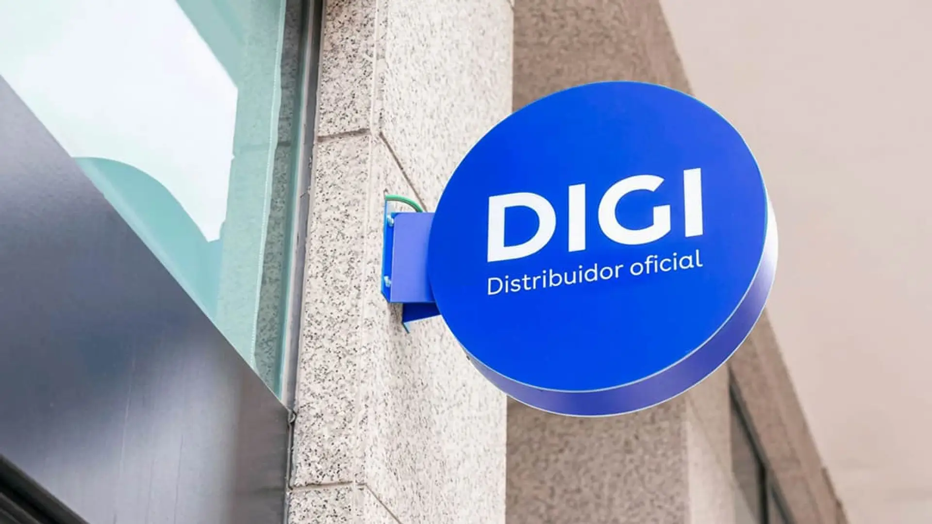 DIGI crece más rápido de lo que puede financiarse: 1.800 millones de deuda sin el colchón de la salida a Bolsa Cartel circular azul de DIGI con el texto Distribuidor oficial en la fachada de un establecimiento comercial.