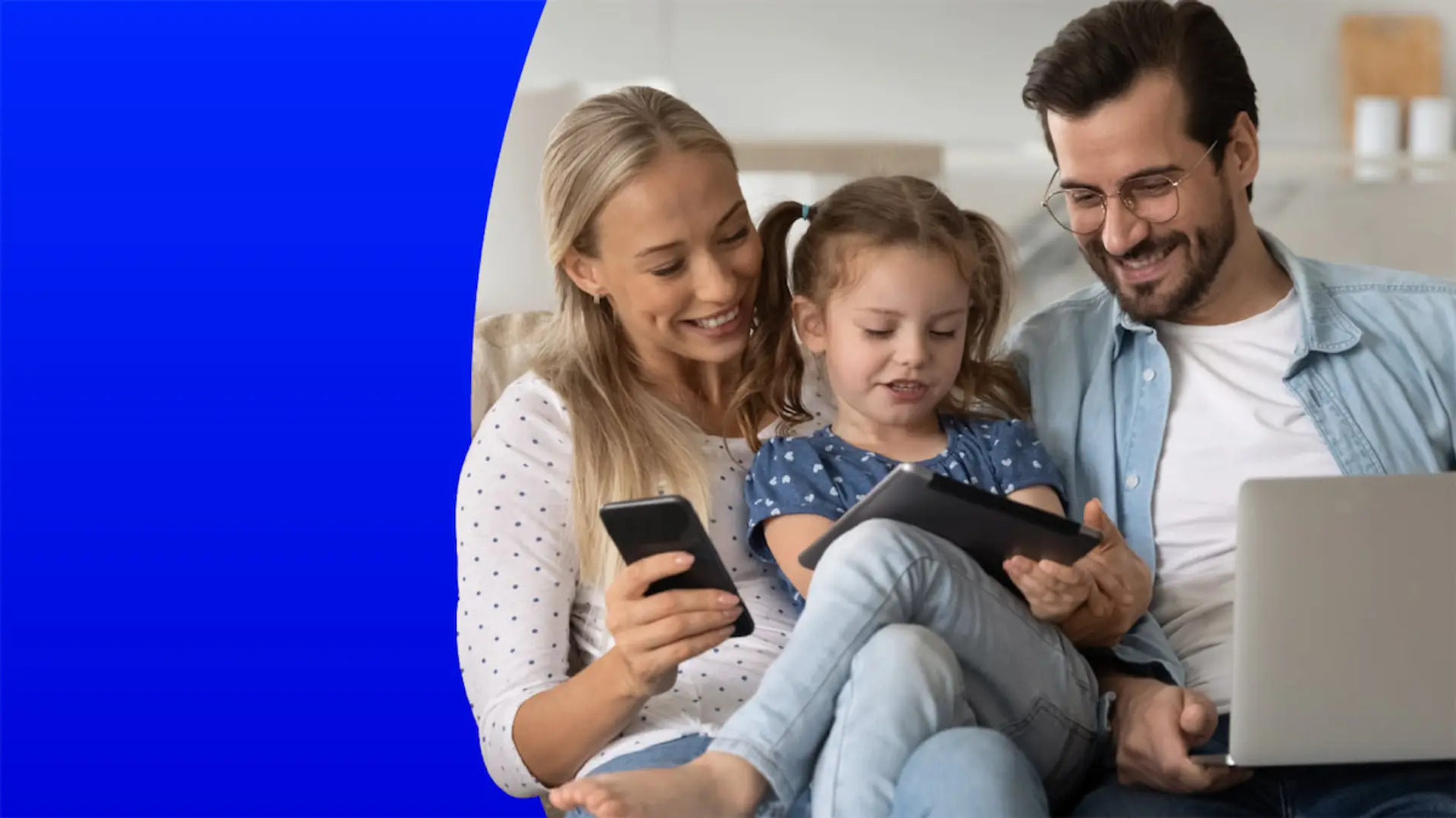 DIGI revienta el mercado: datos ilimitados desde 5€ y mejora en su fibra Familia sonriente en el sofá de casa usando a la vez el móvil, la tablet y el portátil conectados a internet.