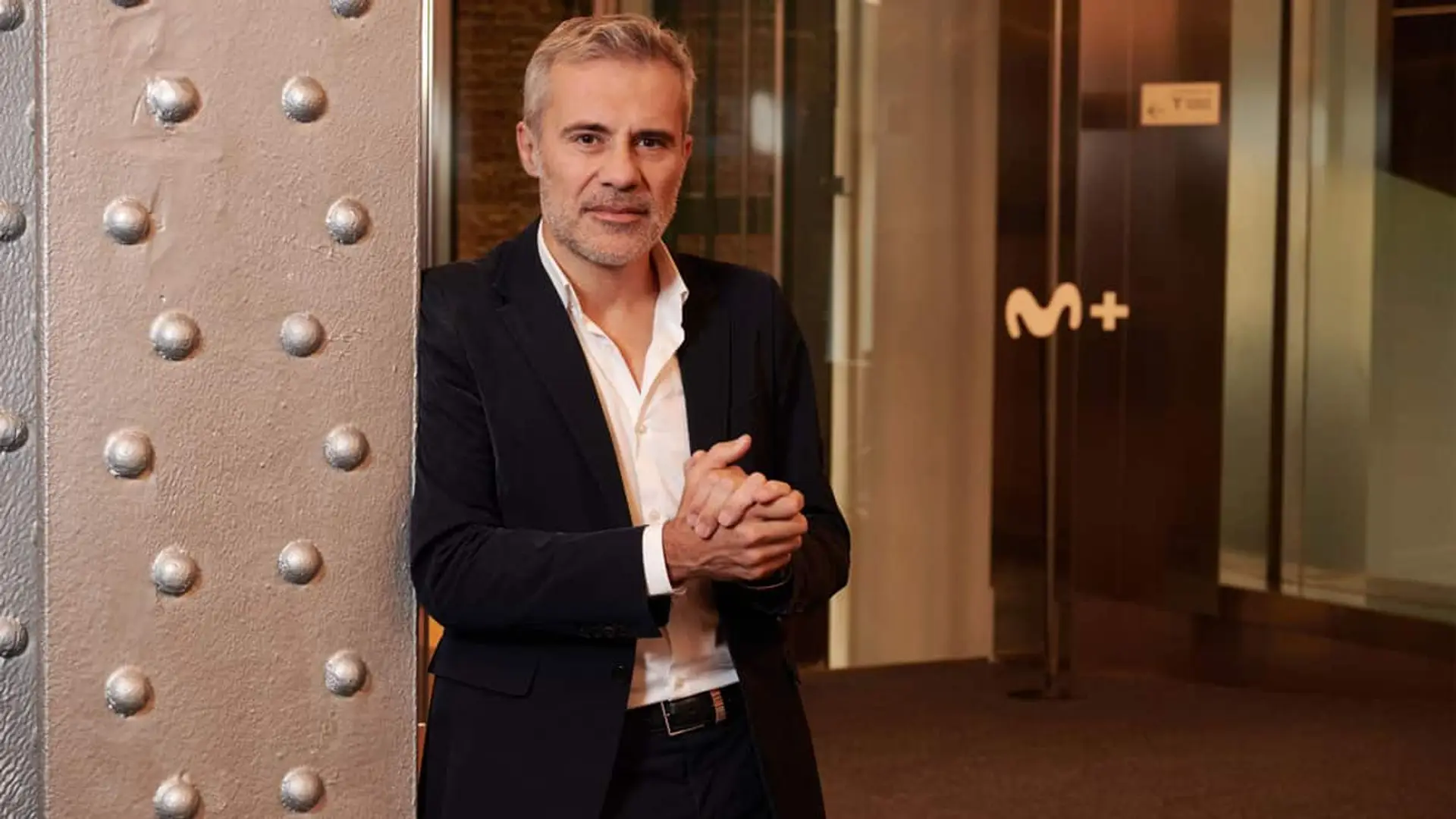 Domingo Corral en una foto promocional de Movistar Plus, de pie apoyado en una columna.
