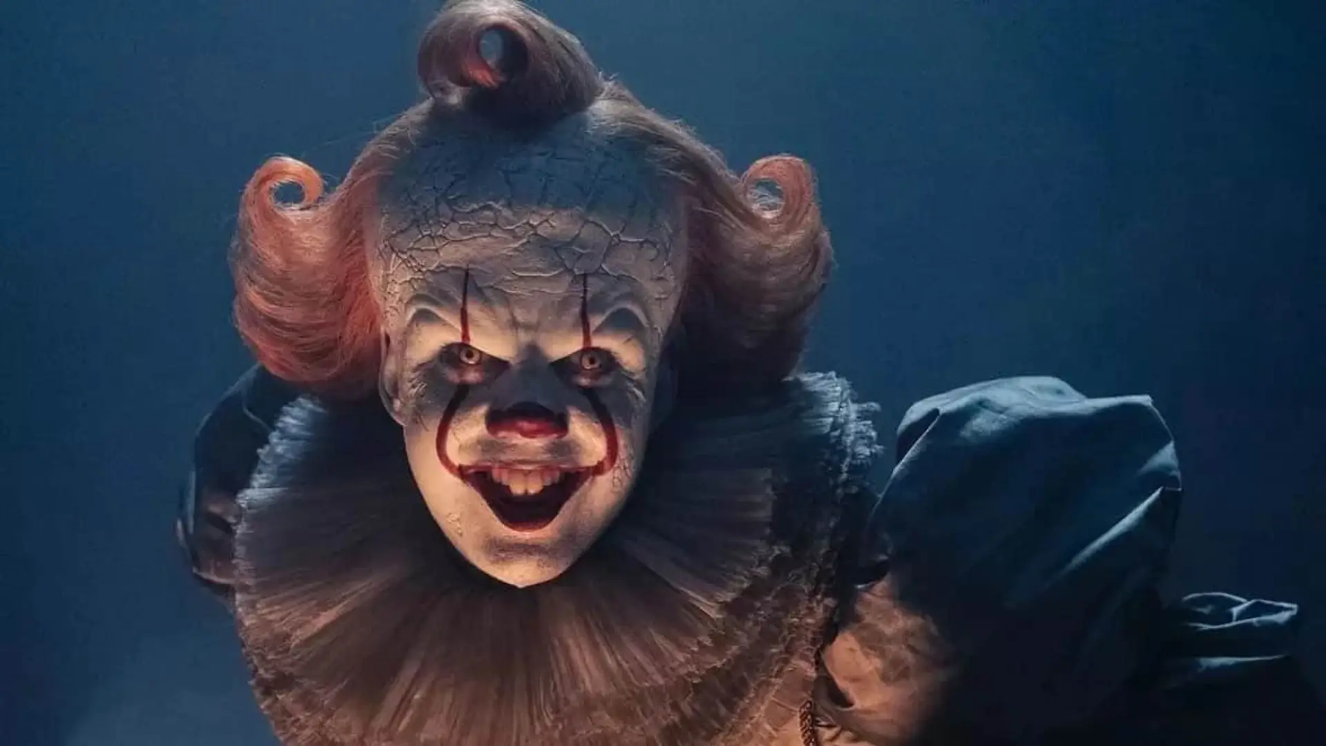 It: Bienvenidos a Derry está arrasando: tanto que HBO Max ha tomado esta sorprendente decisión El actor Bill Skarsgard en Bienvenidos a Derry, la serie precuela de It, con una sonrisa siniestra tras un cristal.