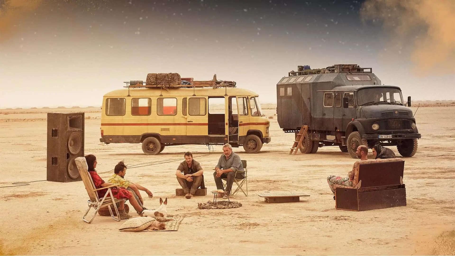 El reparto de la película Sirat de Movistar Plus+ acampando en el desierto junto a sus vehículos y un equipo de sonido.