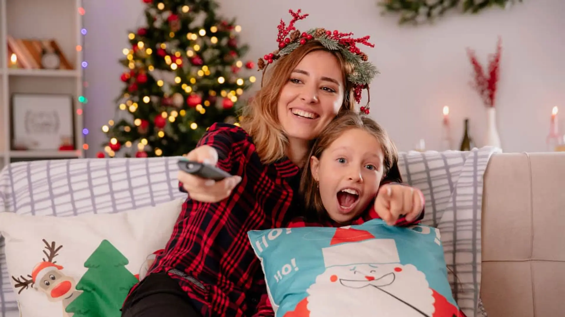Movistar Plus+ guarda un as bajo la manga y anuncia estos estrenos que llegan por sorpresa en diciembre Madre e hija emocionadas viendo la televisión en Navidad con decoración festiva y mando.
