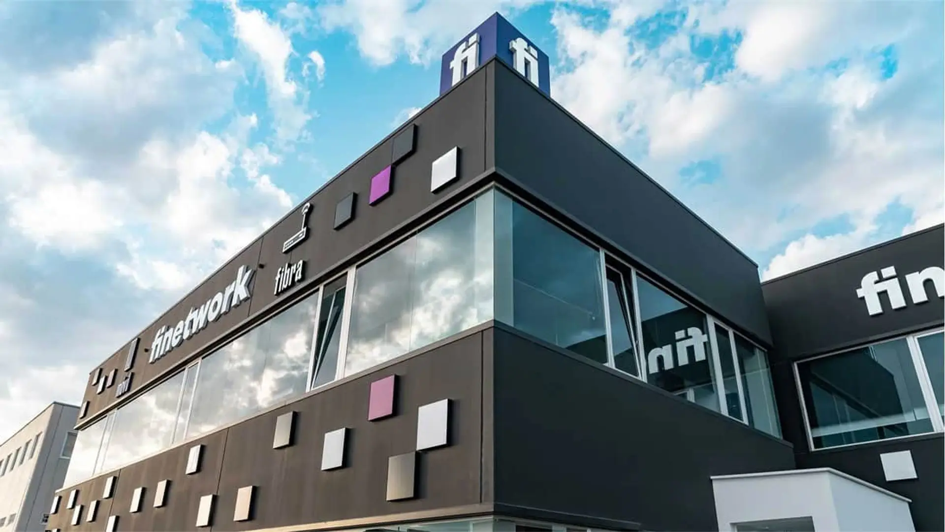 Fachada del edificio de oficinas de la operadora de fibra y móvil Finetwork con su logotipo corporativo.