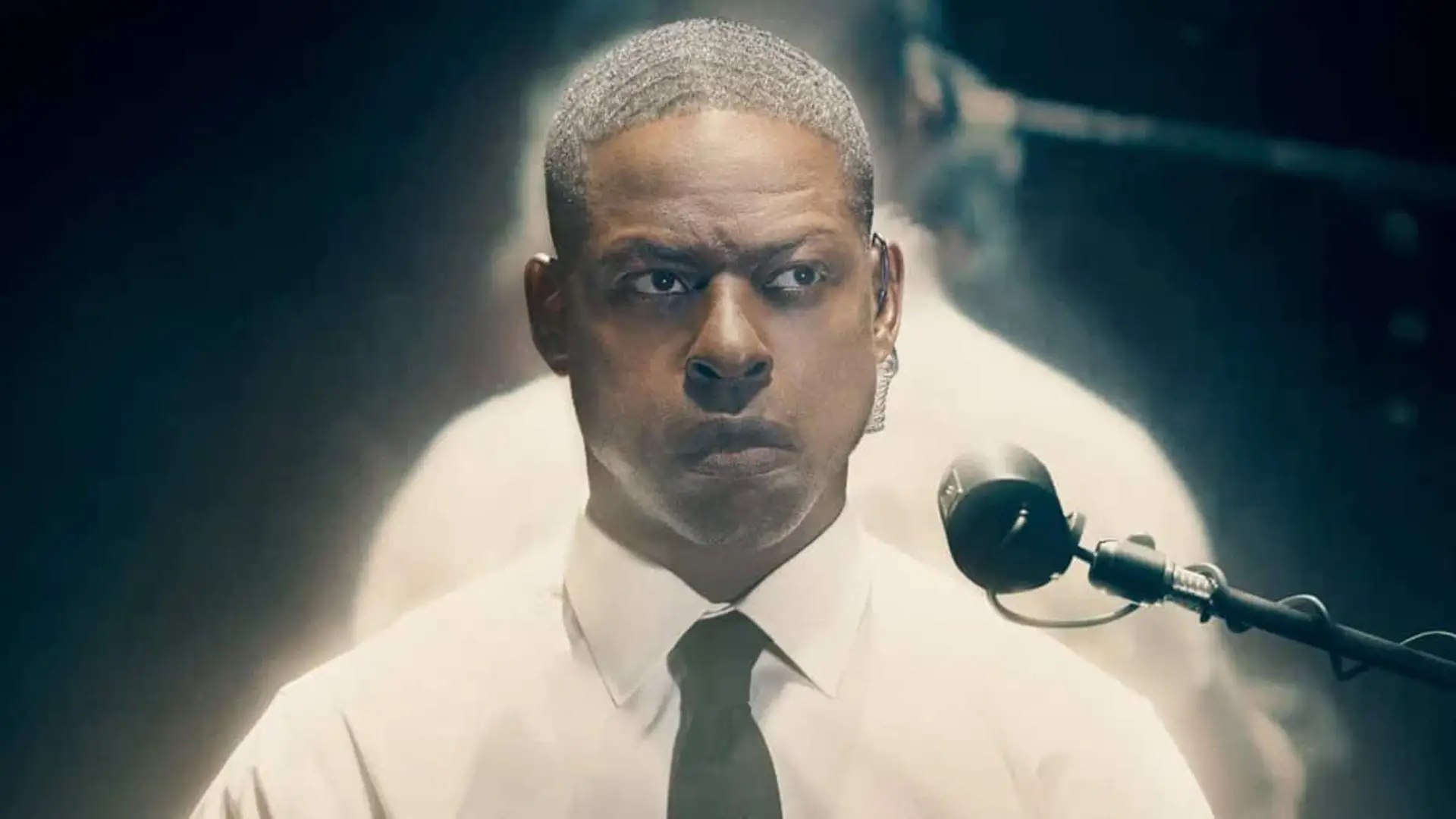 El protagonista de Paradise en una escena de la segunda temporada de la serie, con cara seria en un interrogatorio.