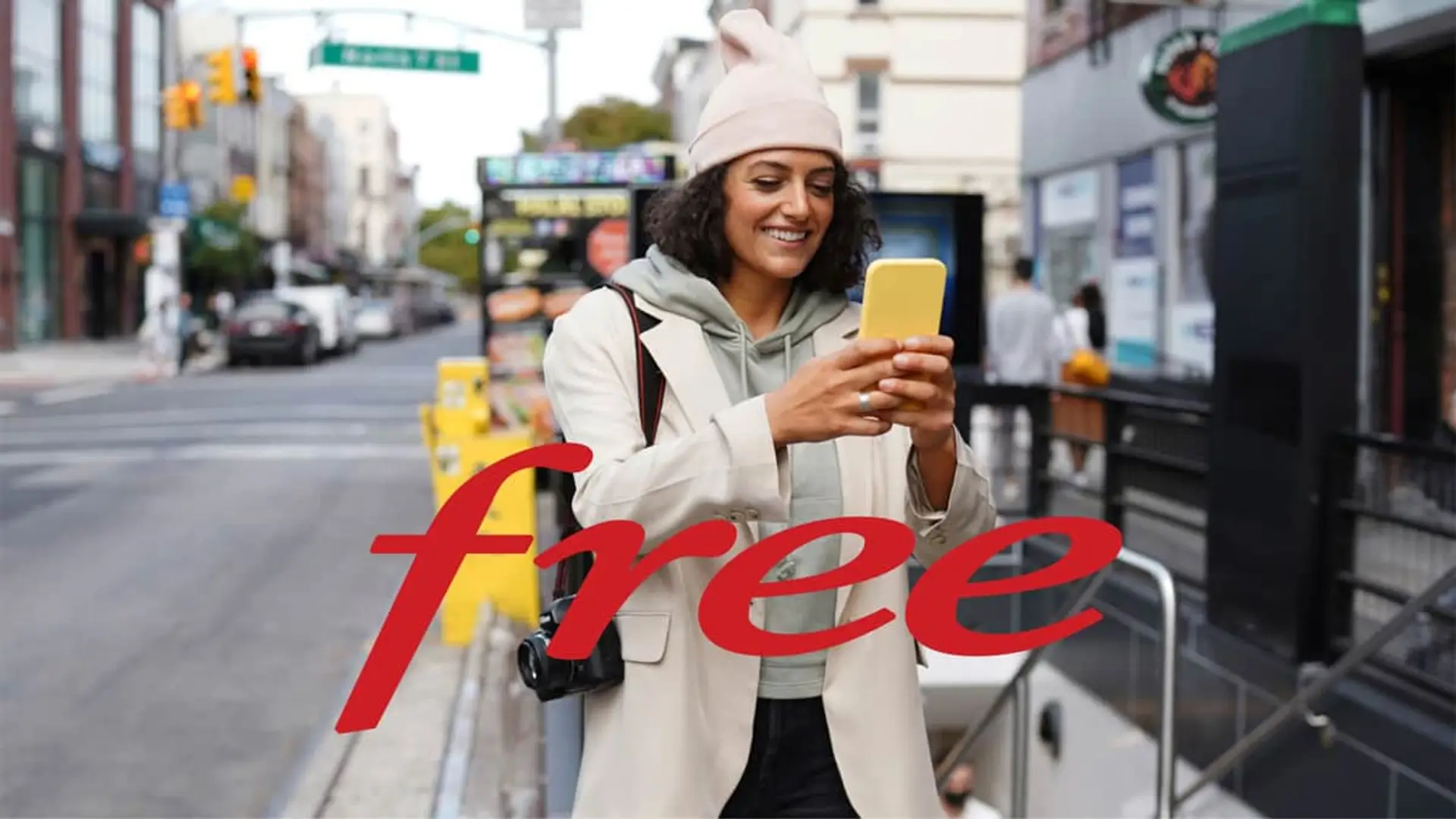 Mujer con gorro y móvil junto al logotipo de Free para representar sus servicios de telefonía y red móvil internacional.